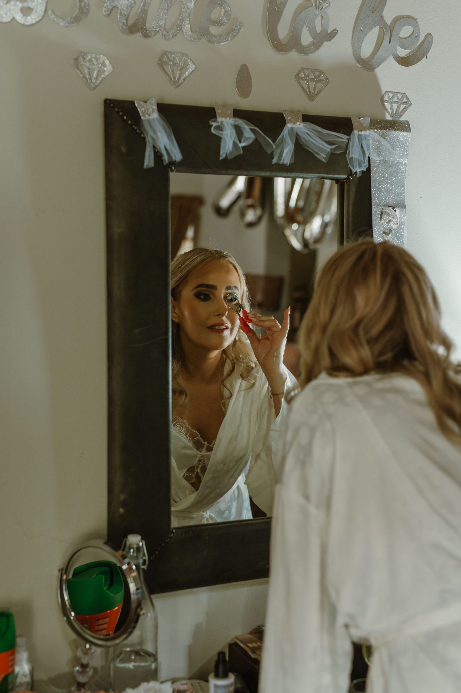 Wedding preparation scene with diamond decorations visible in mirror reflection.