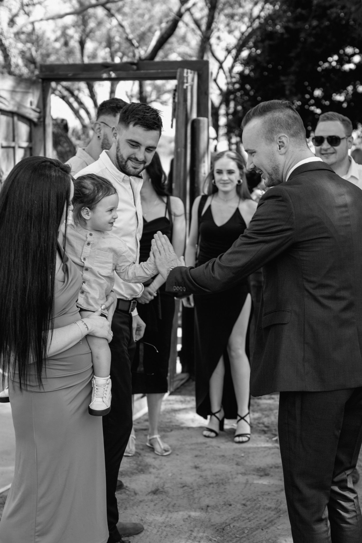 Wedding guests interacting during outdoor reception festivities.