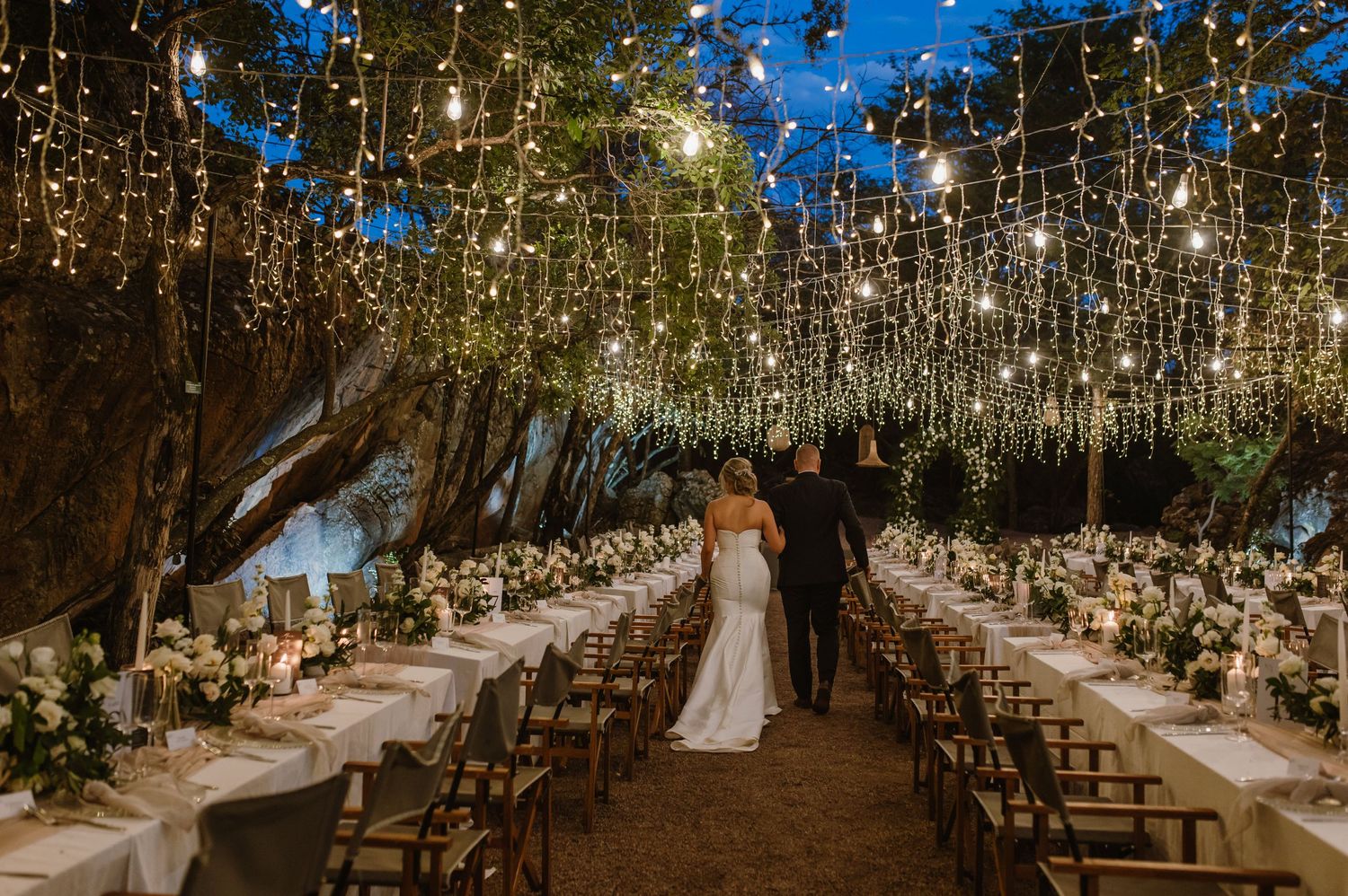 Enchanting outdoor wedding ceremony setup with hanging fairy lights creating a magical canopy.