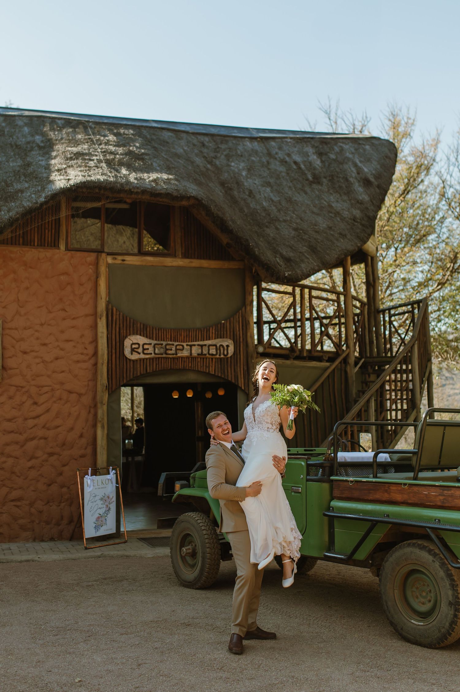 Playful moments near vintage safari vehicles at rustic outdoor venue.