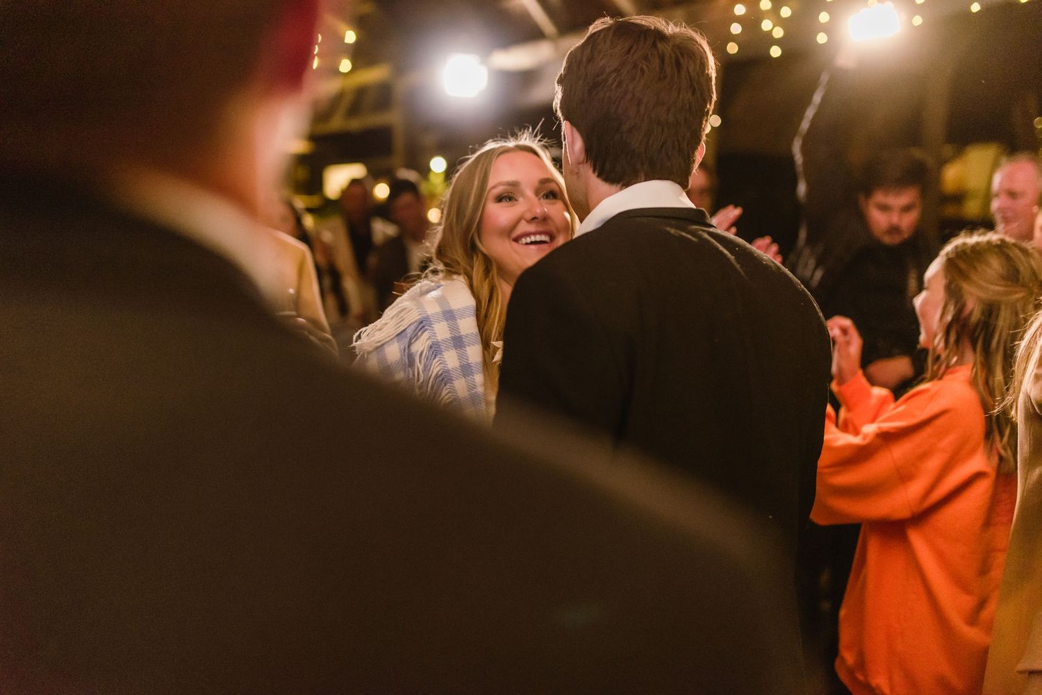 Guests enjoying a lively dance celebration under warm lighting at a rustic venue.
