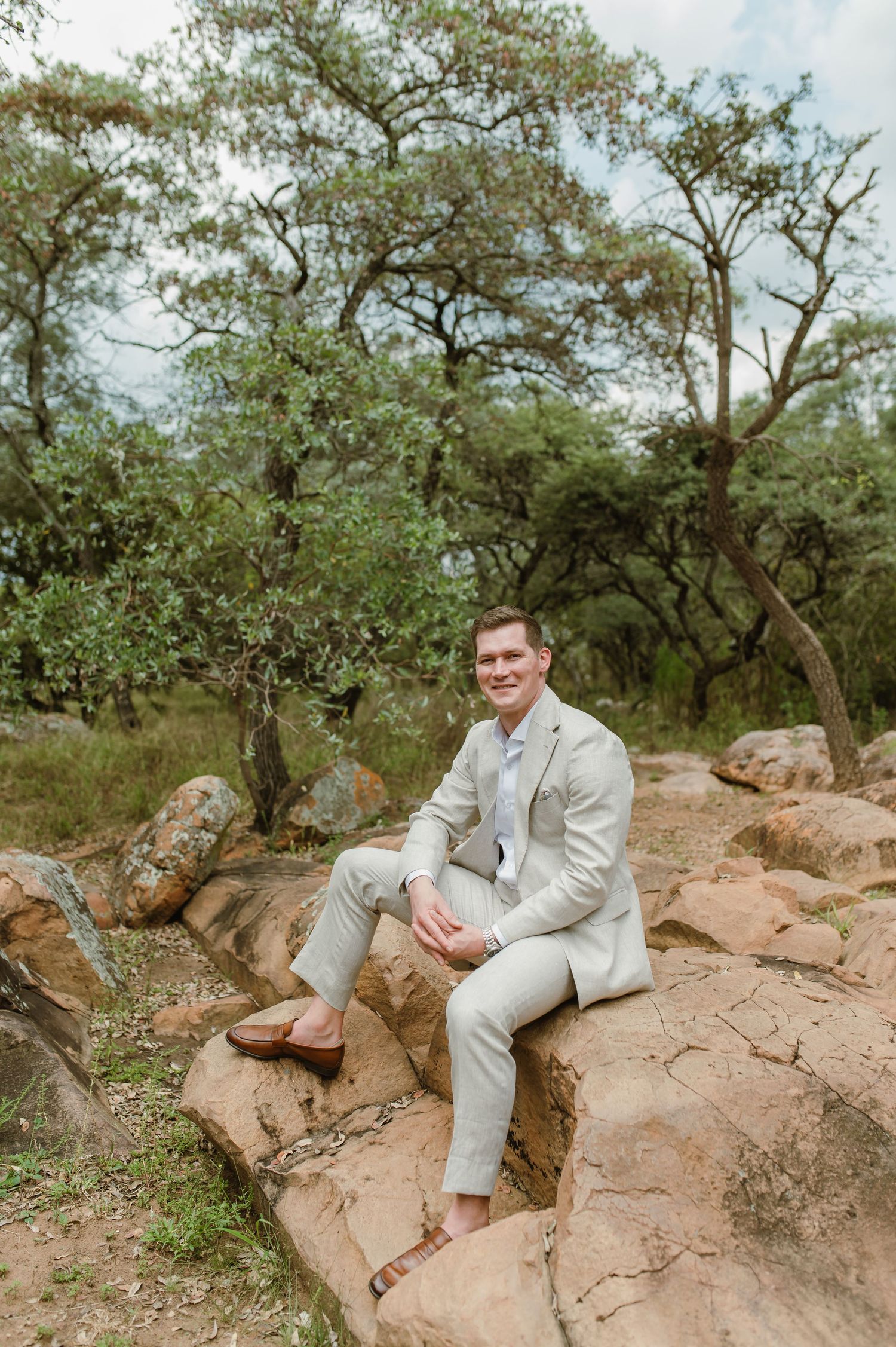 Formal attire photo taken in a natural setting with rocks and trees in the background.