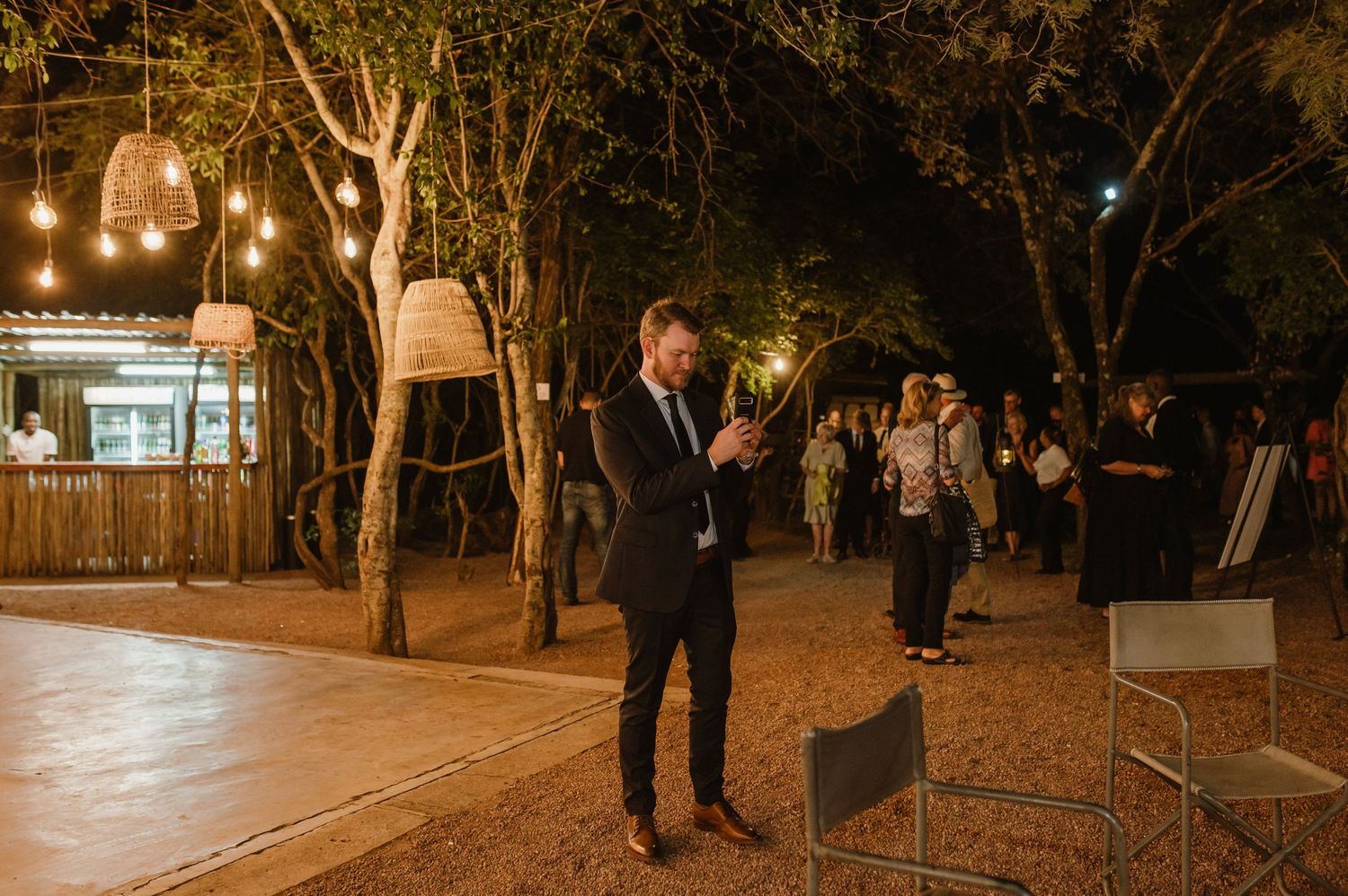 Evening outdoor event space illuminated by warm lighting and natural surroundings.