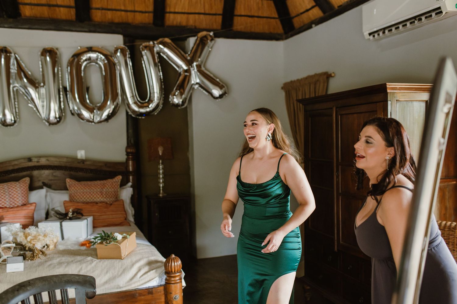 Wedding detail shot showing silver balloon letters spelling out text against a rustic ceiling.