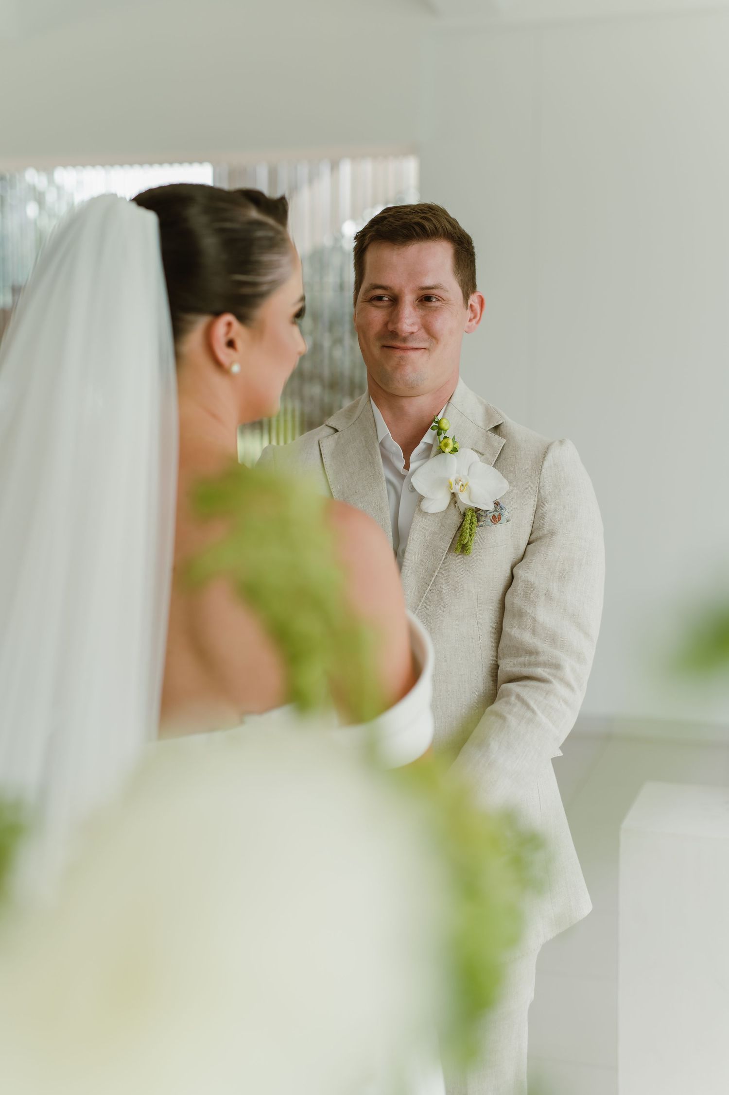 Intimate wedding ceremony moment captured in a bright modern white interior space.
