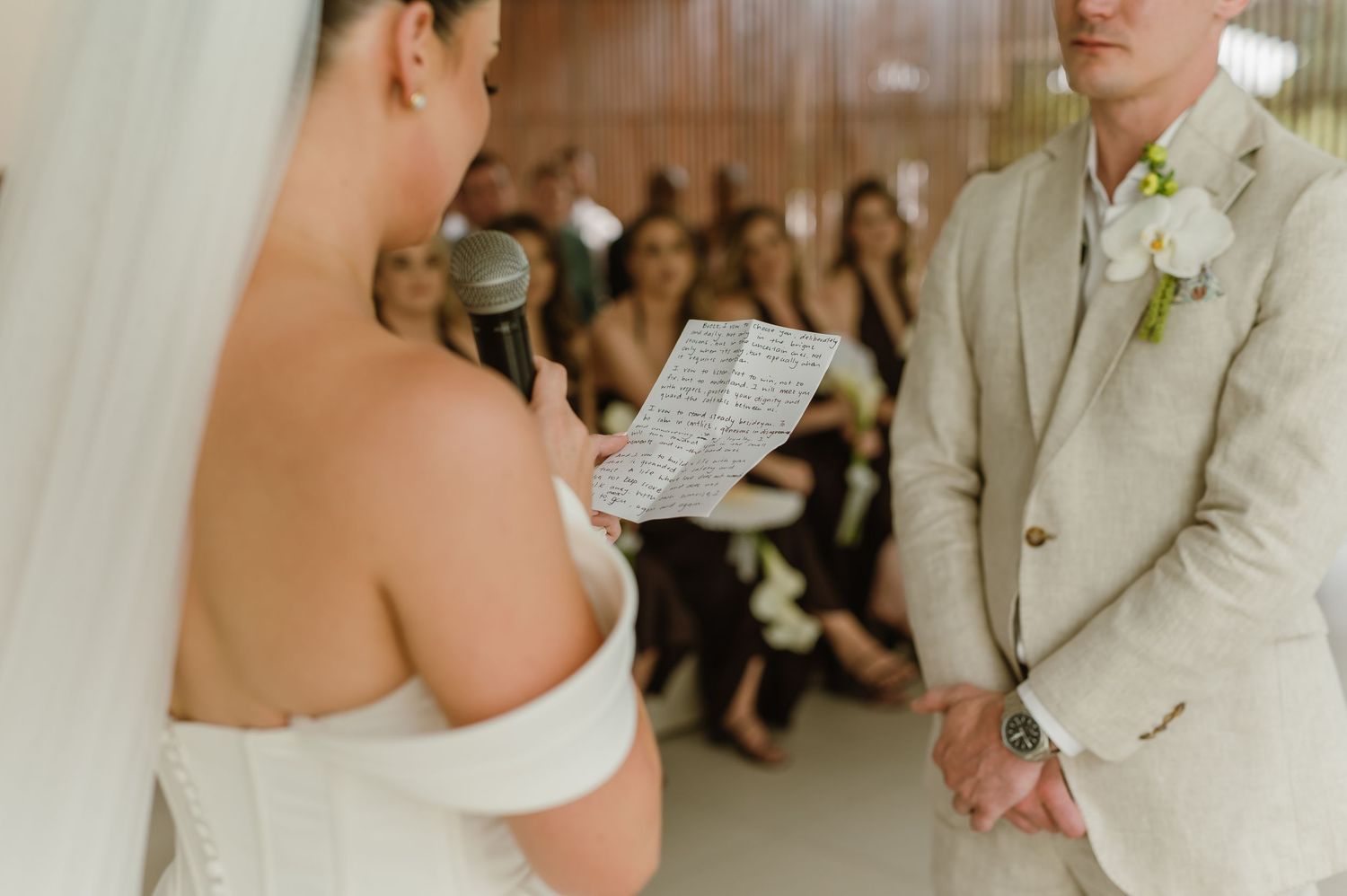 Wedding ceremony with couple reading vows in front of gathered guests.