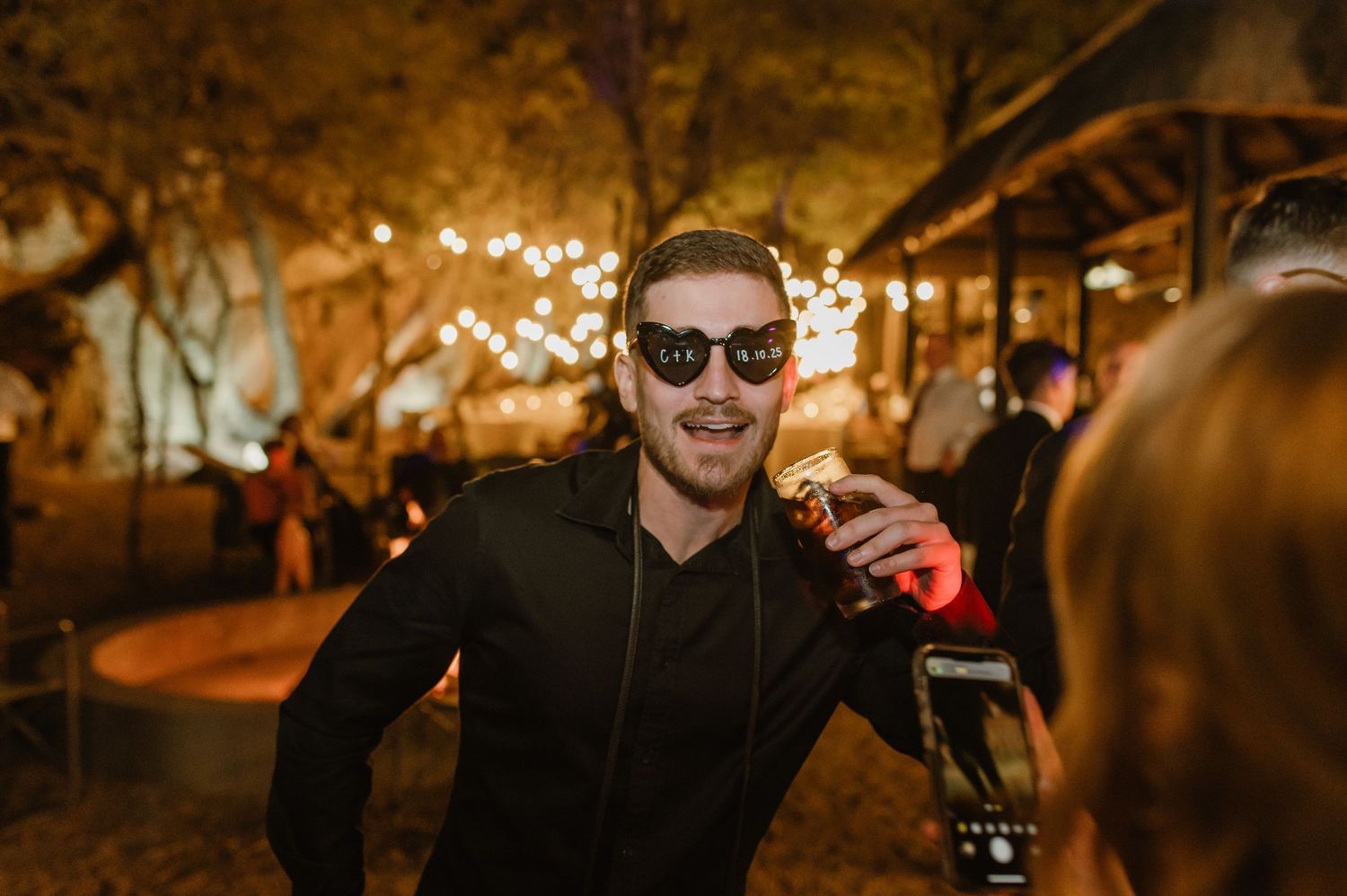 Guests mingle and socialize at an evening outdoor event with ambient lighting.
