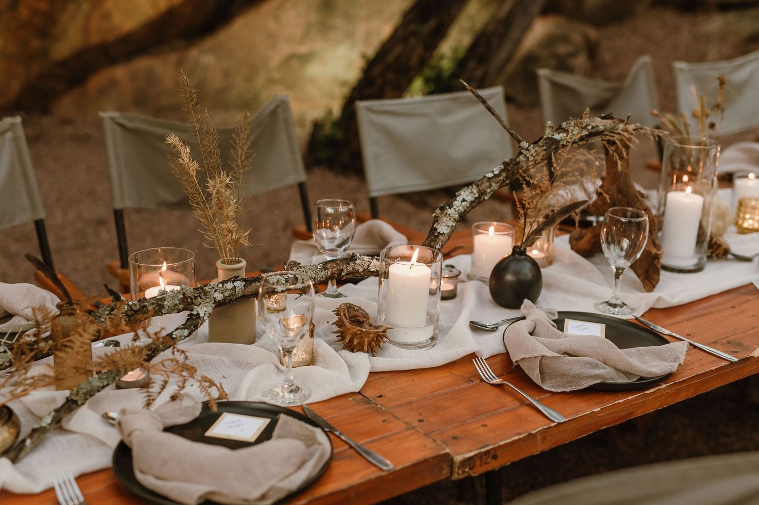 Intimate table settings with white linens and candlelight creating a romantic outdoor dining atmosphere.