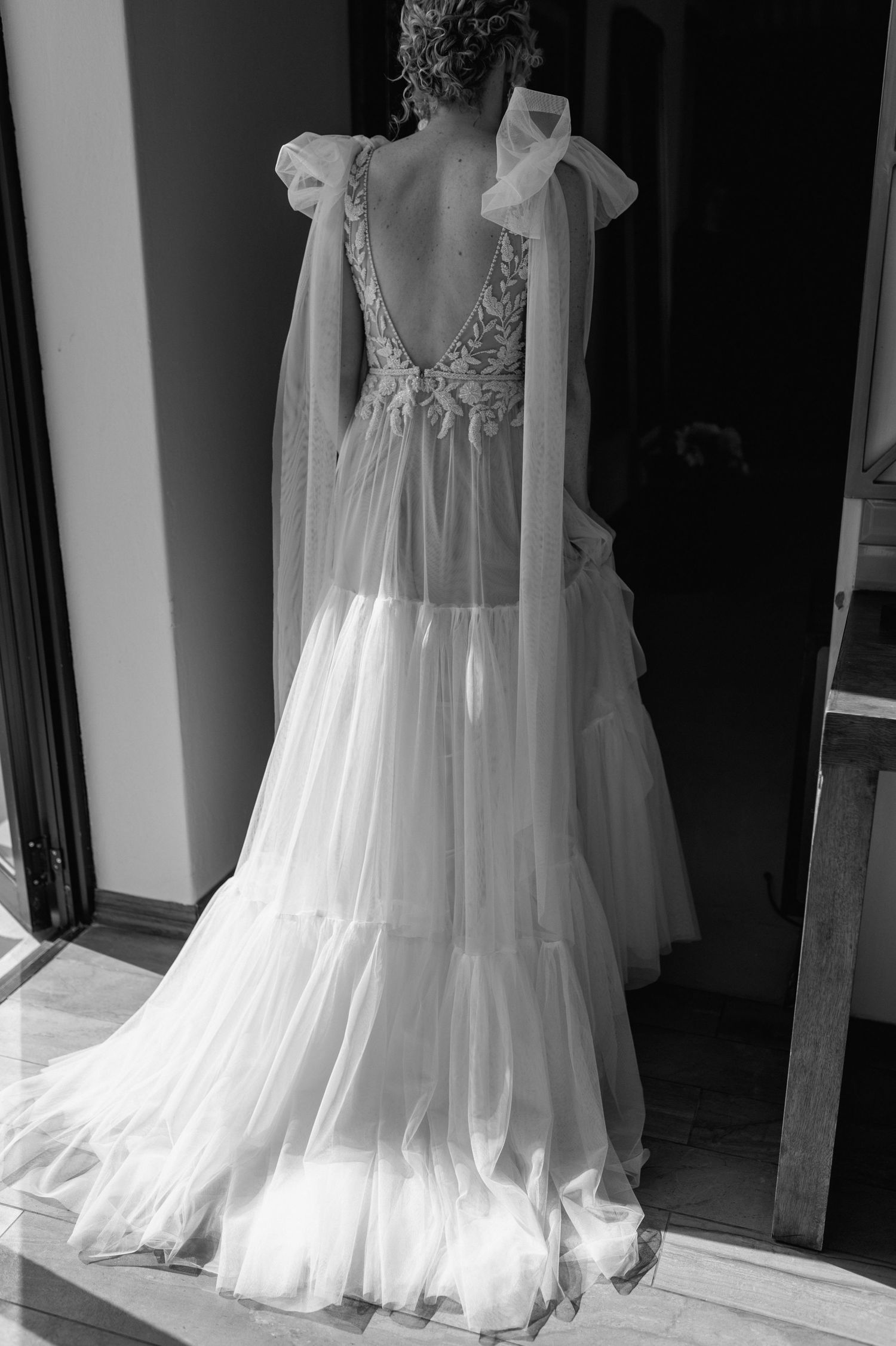 Black and white photo of a flowing wedding dress with delicate lace bodice.