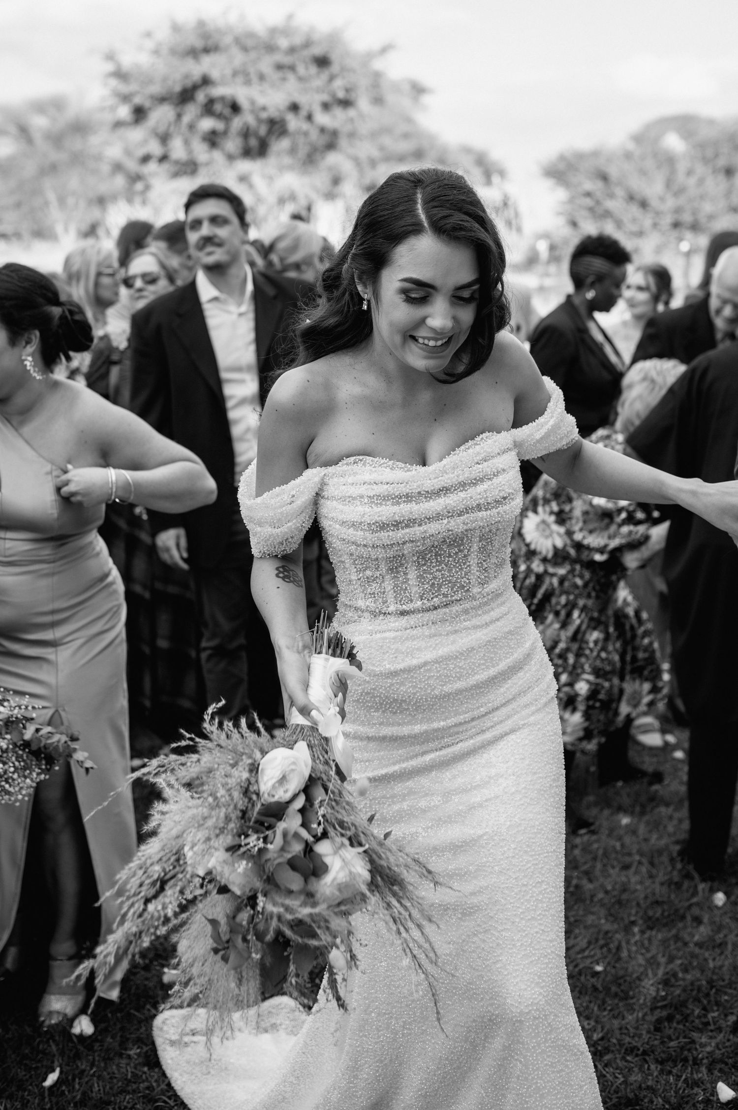 Detail shots of an elegant strapless wedding dress with beading and a floral bouquet.
