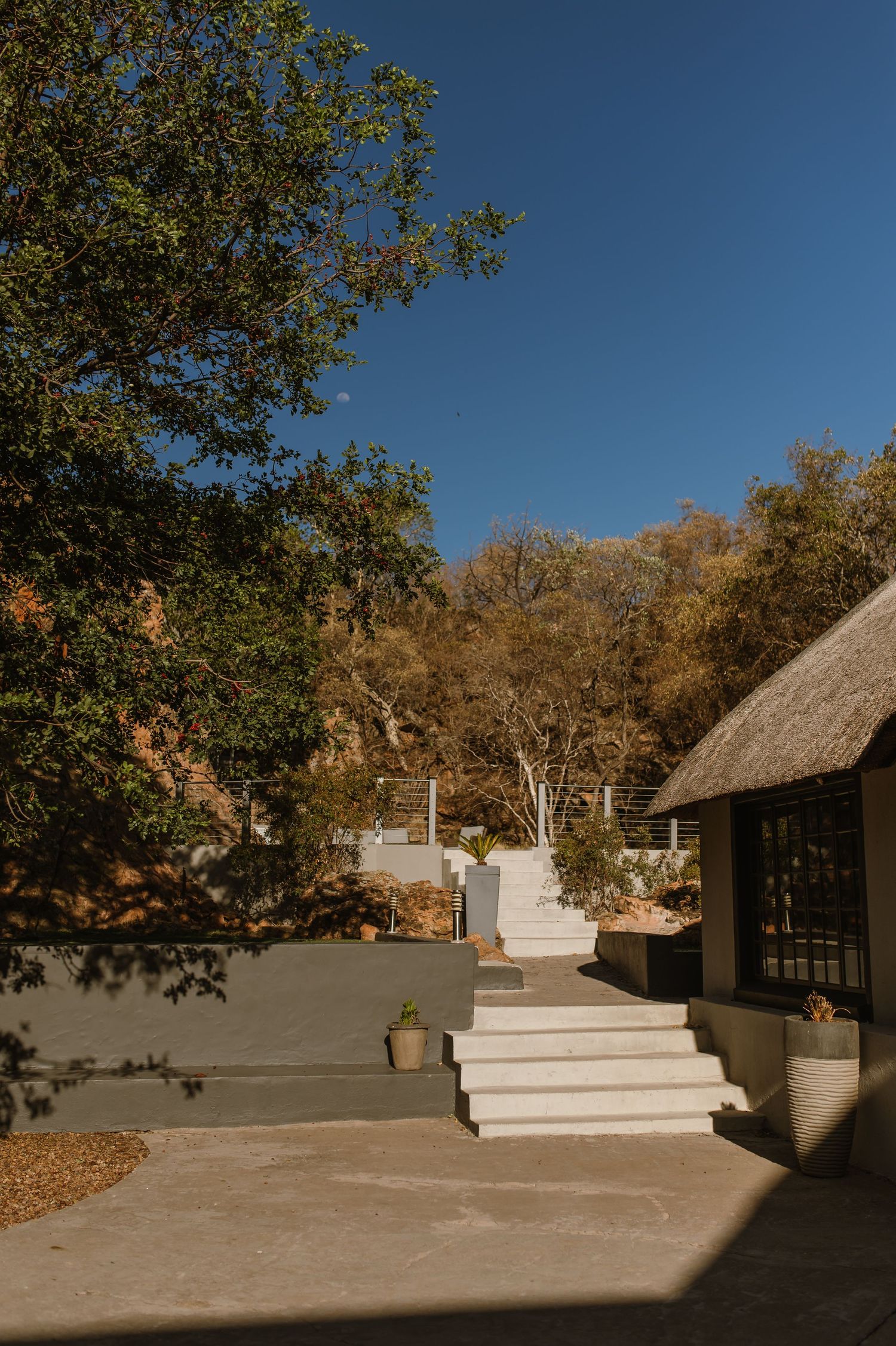 Modern outdoor venue with white steps and thatched roof structures.