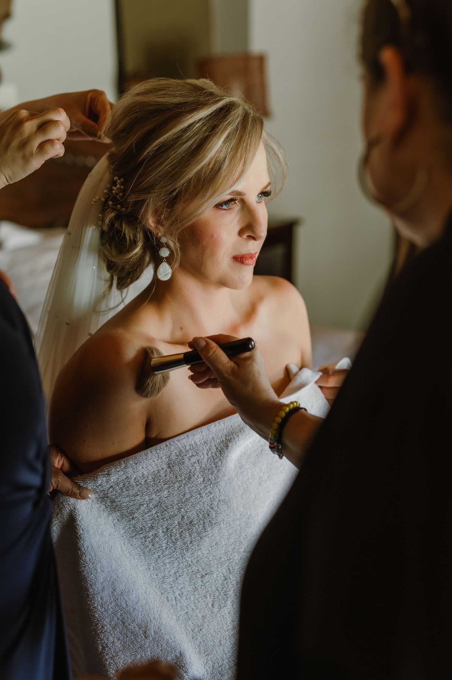 Getting ready moments with makeup application in a white robe.