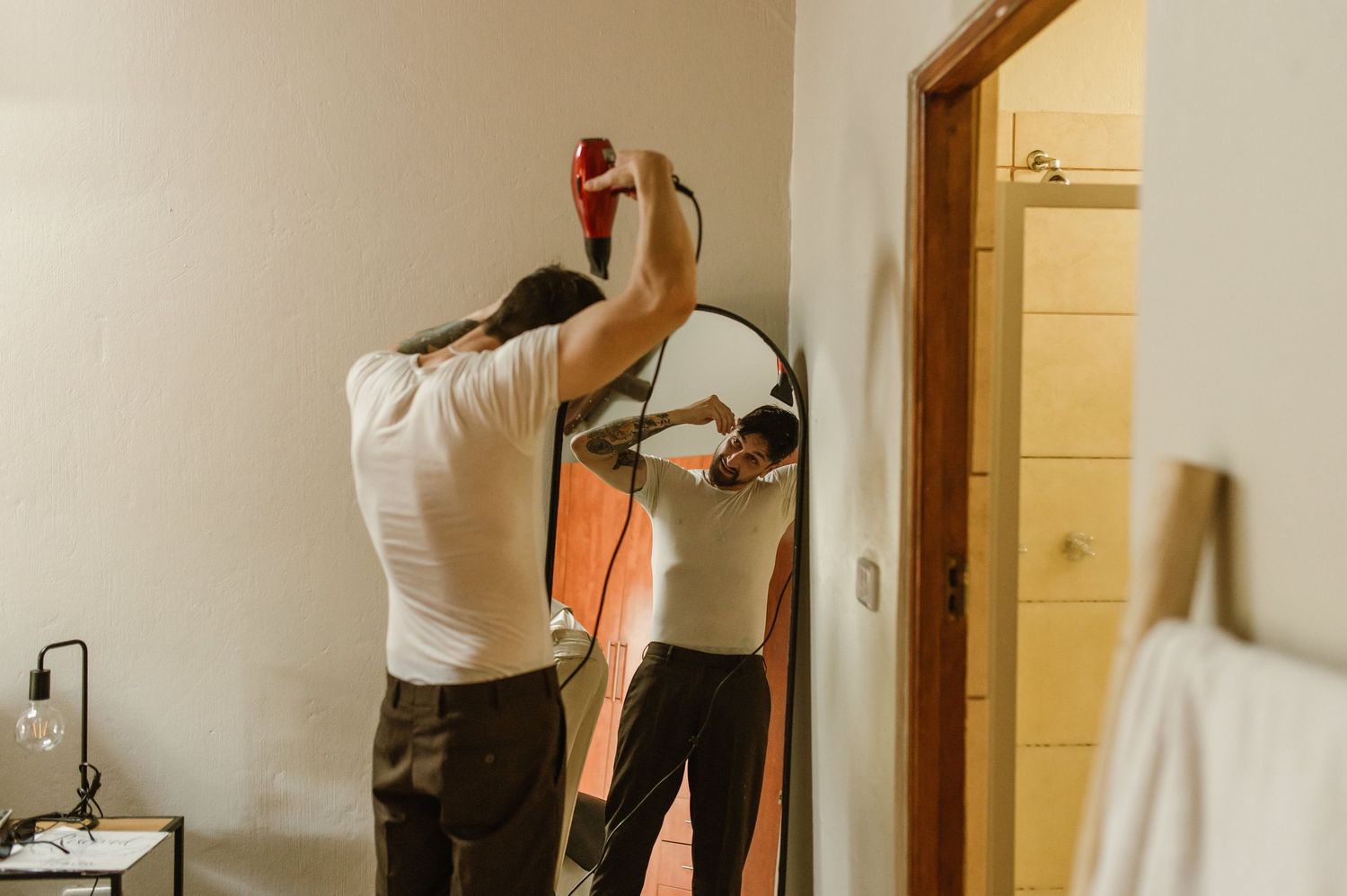 Interior preparation scene with formal attire being adjusted in a mirror.