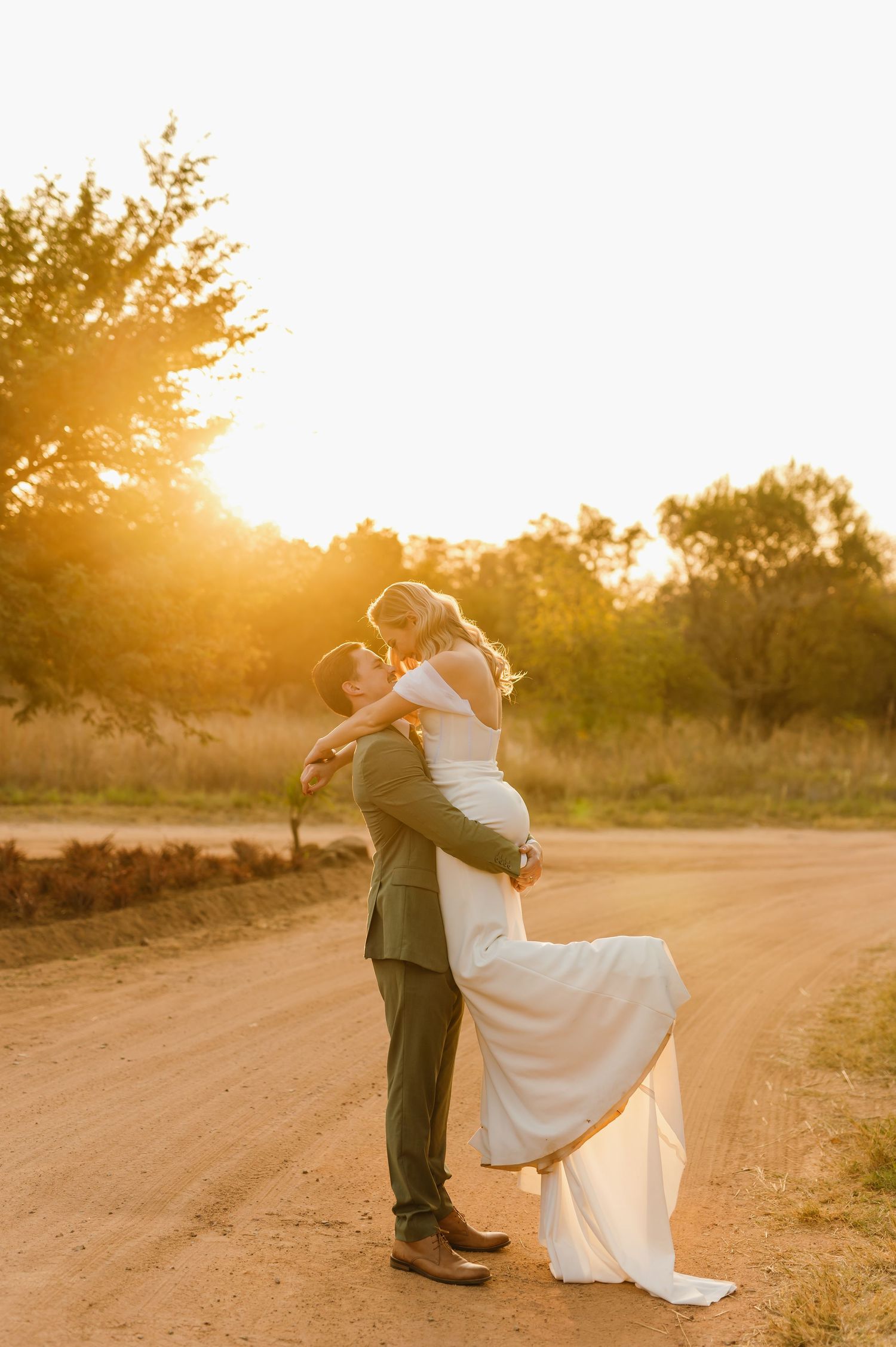 Couple performs romantic dance moves on a dirt path bathed in warm sunset light.