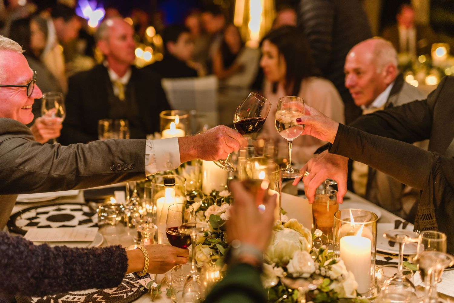 Wedding reception tables adorned with glowing candles and delicate floral arrangements.