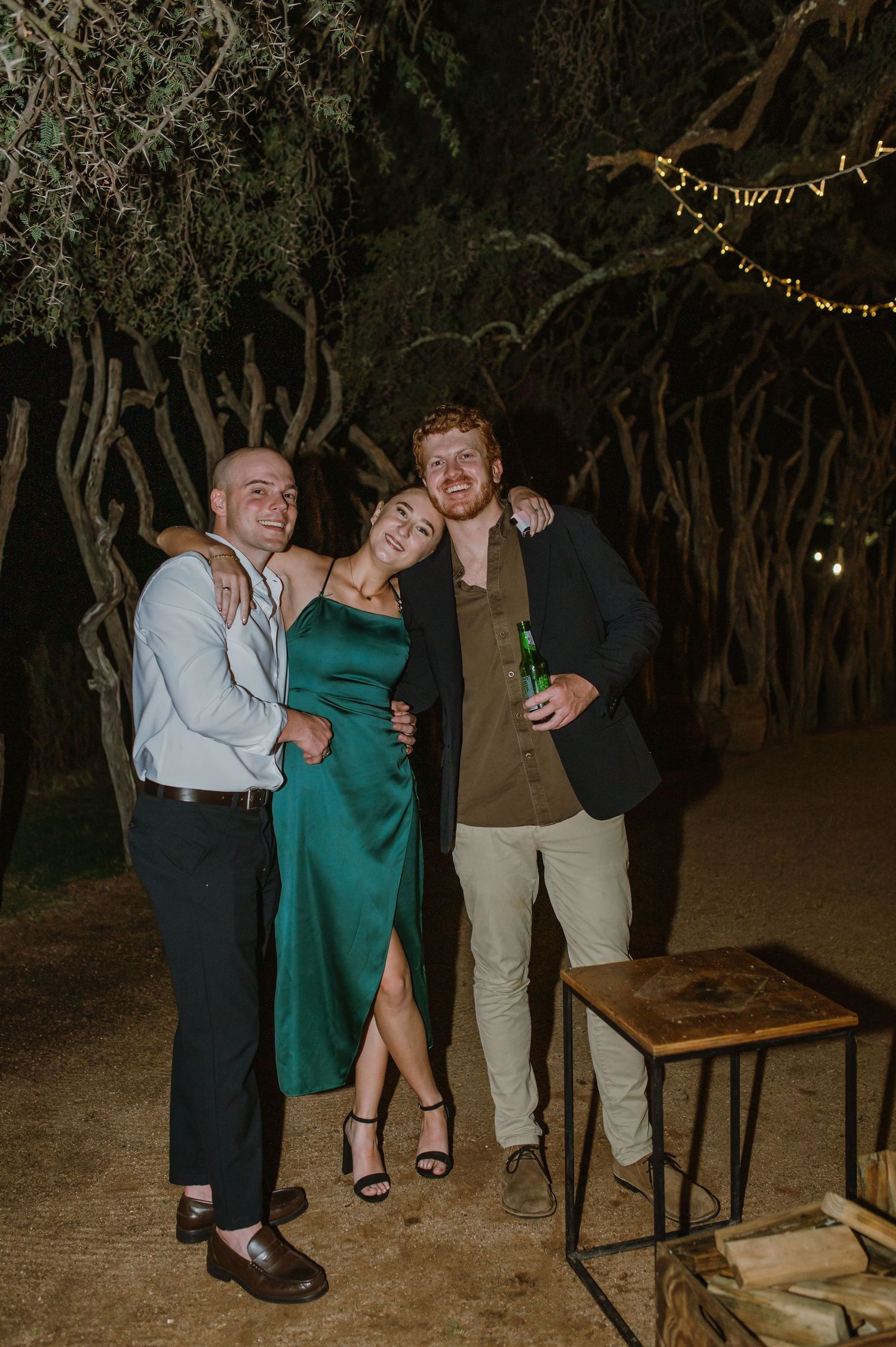 Evening outdoor party scene with string lights illuminating the trees.