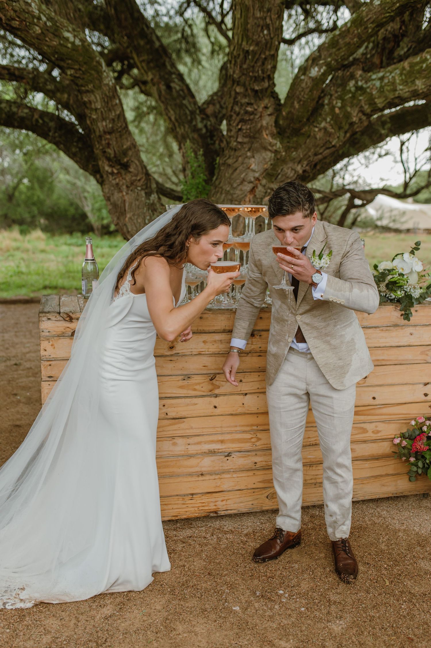 Couple and guests celebrating with a champagne toast at their outdoor wedding reception.