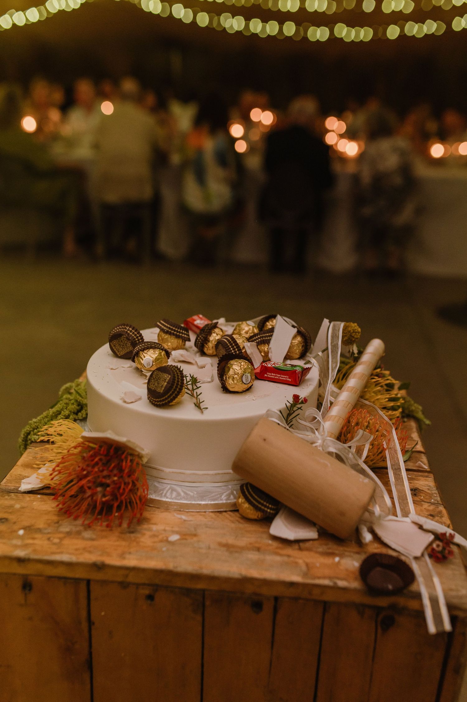 Rustic wooden buffet table with appetizers and serving utensils at an evening event.