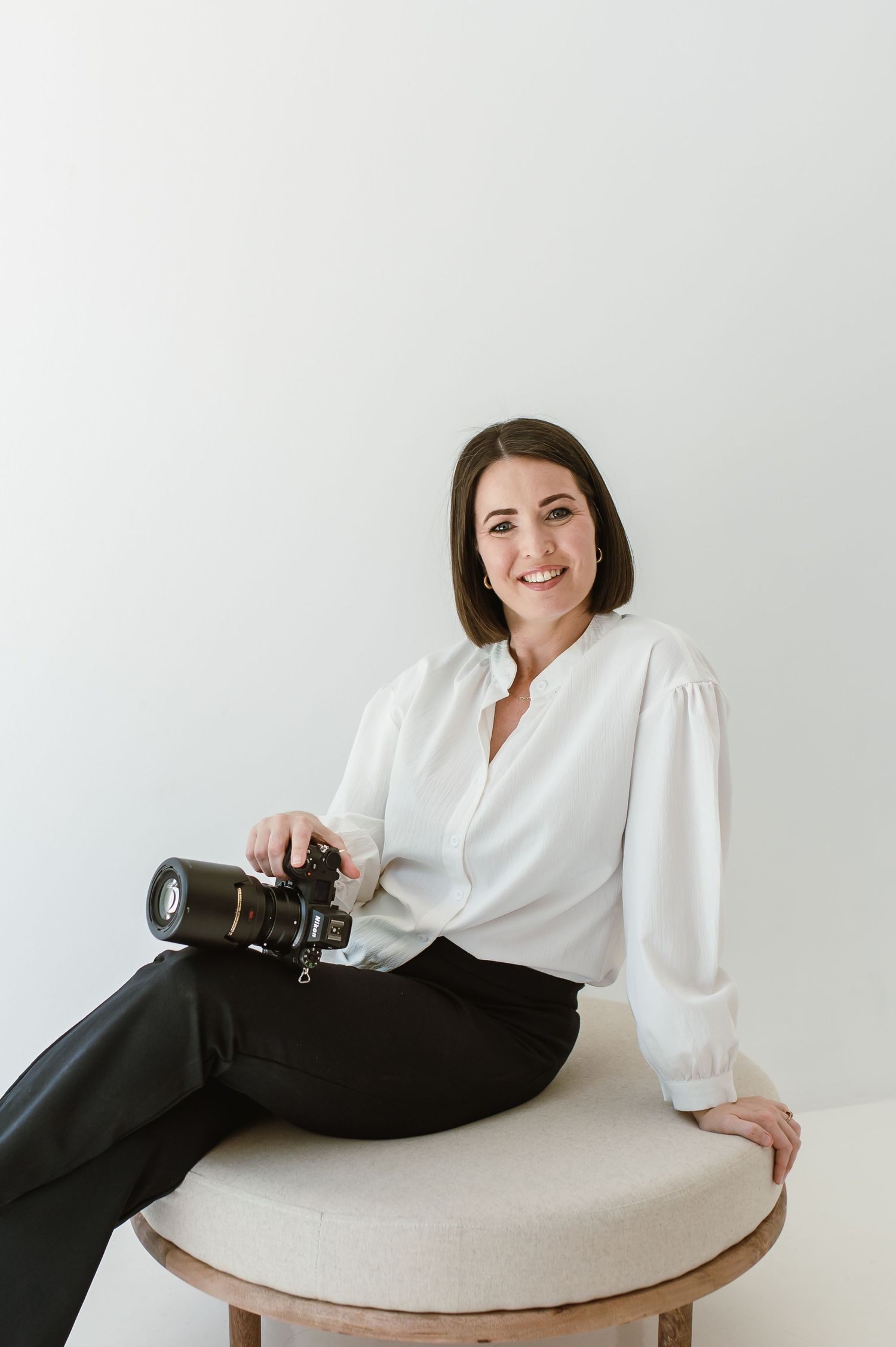 Professional business portraits of woman in white blouse posing on light background.