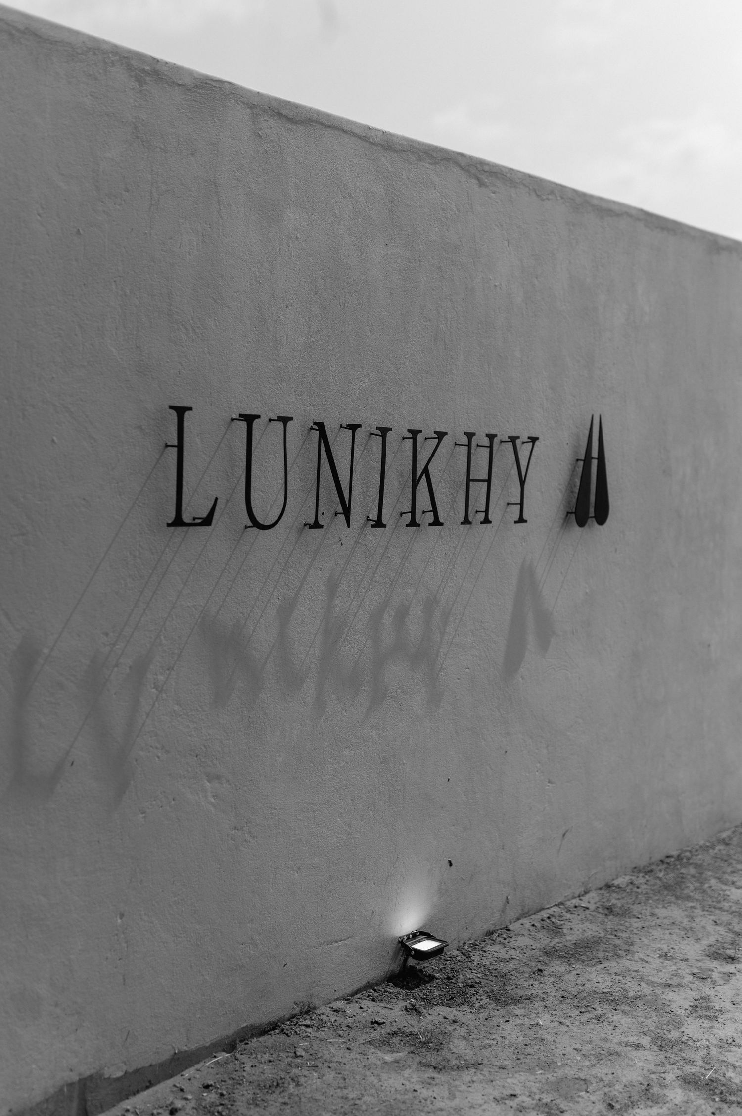 Black text on a white wall showing partial lettering in an artistic style.