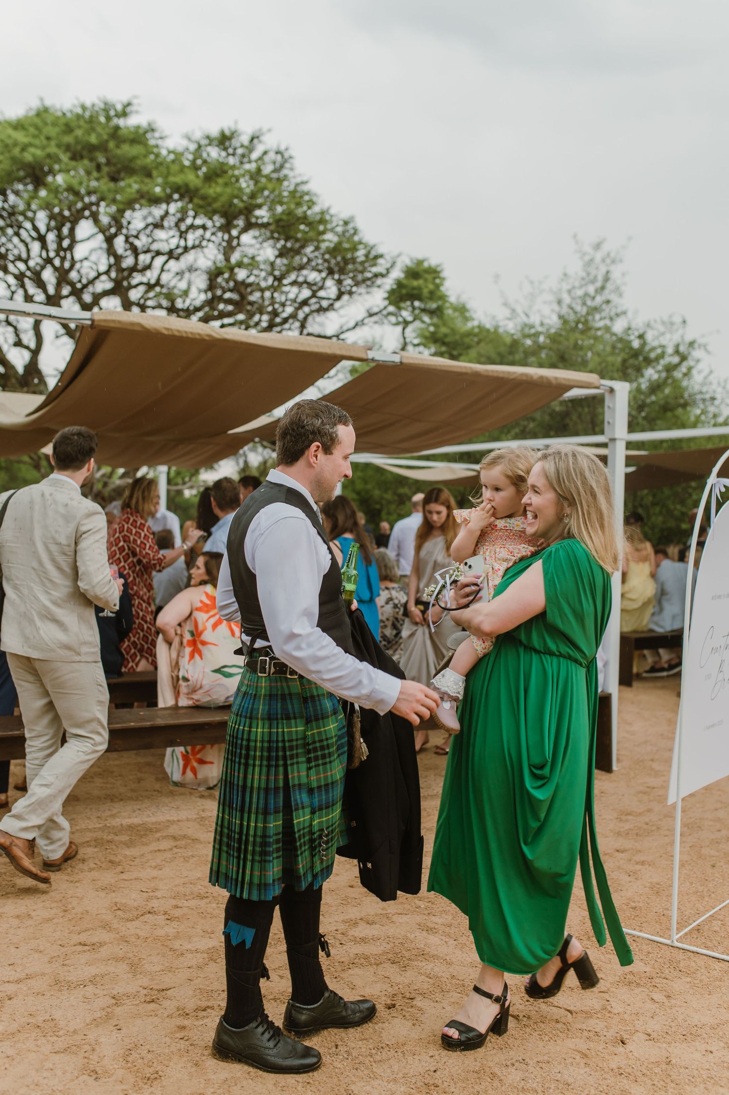 Wedding celebration with guests dancing in traditional Scottish kilts and formal attire.