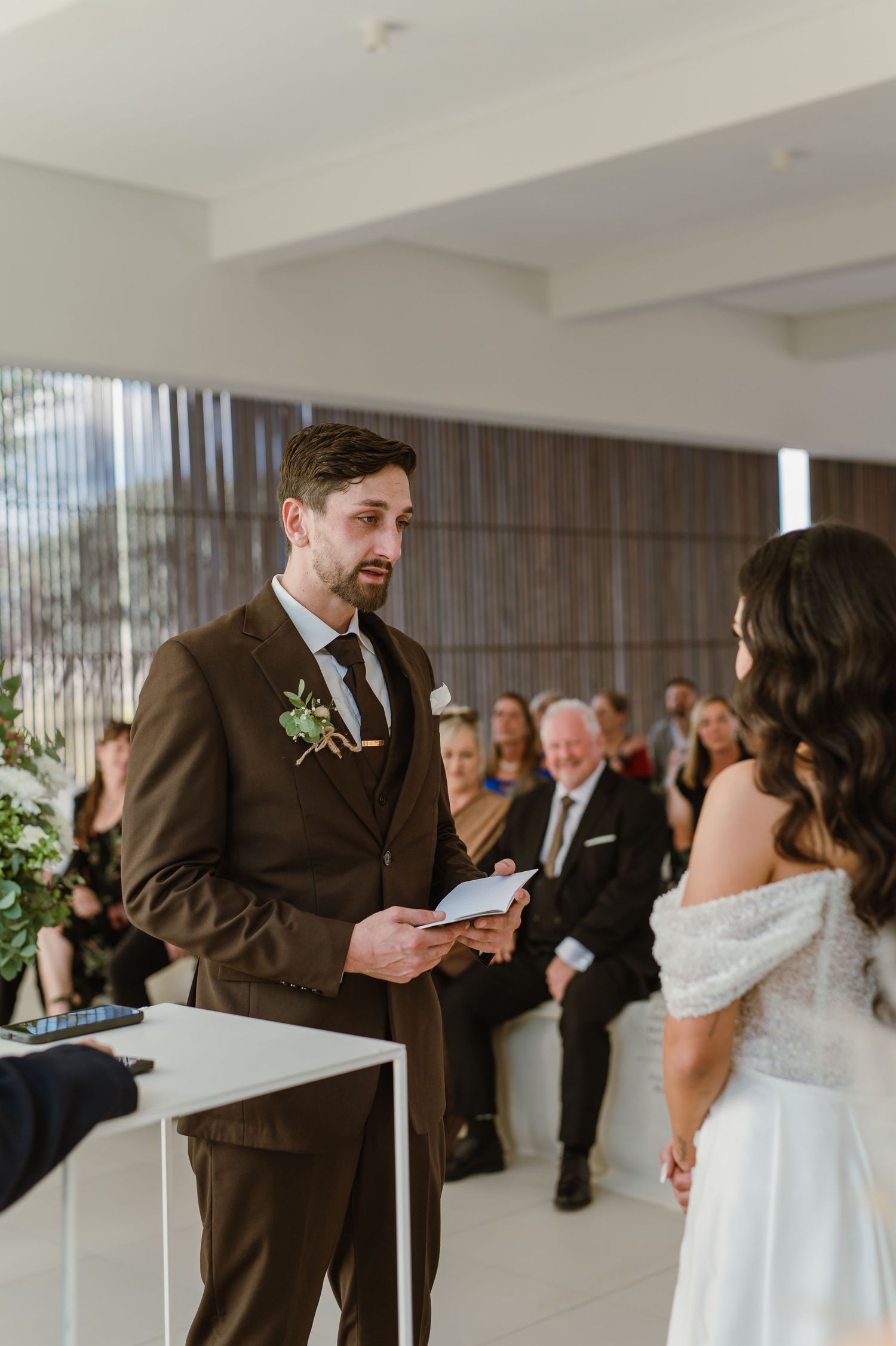 Wedding ceremony first look moment captured in a bright modern indoor venue.