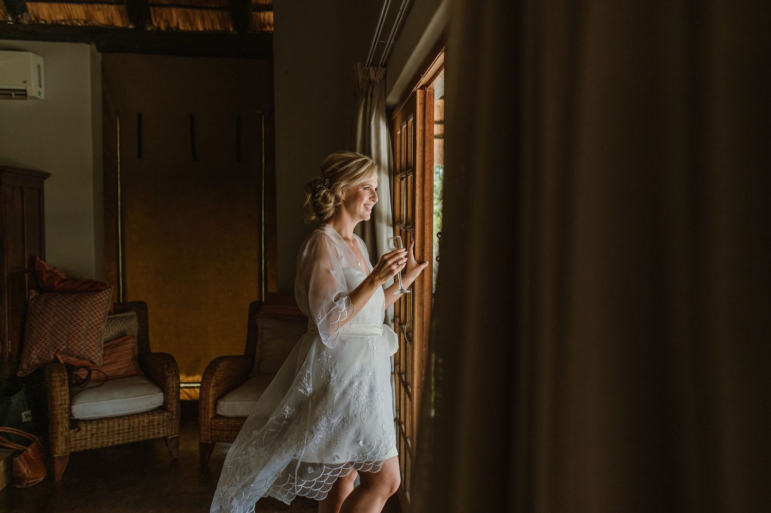 Elegant bridal preparation room with soft natural lighting and window views.
