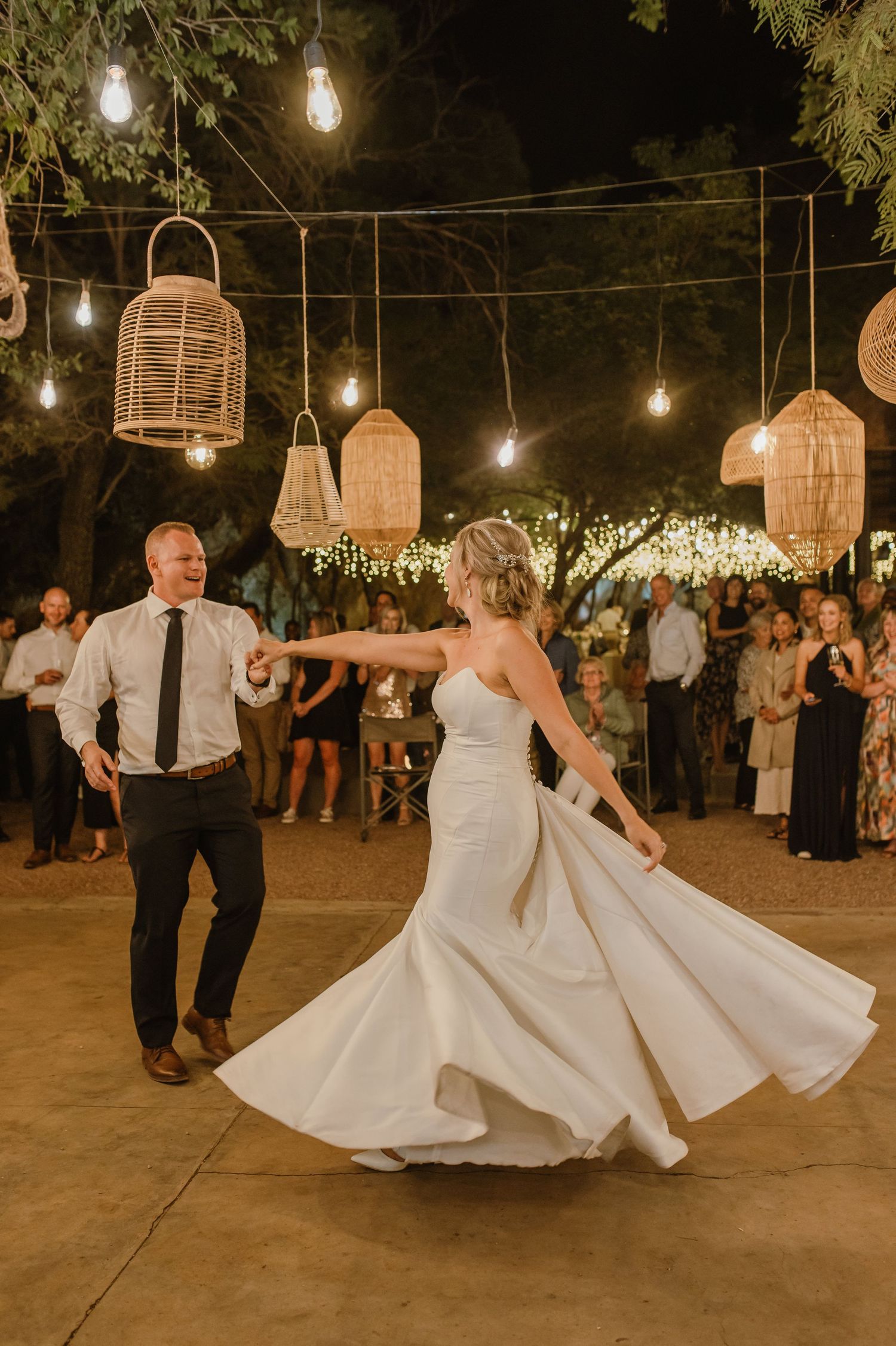 Elegant dance moves captured during wedding reception with twirling white dress under ambient lighting.