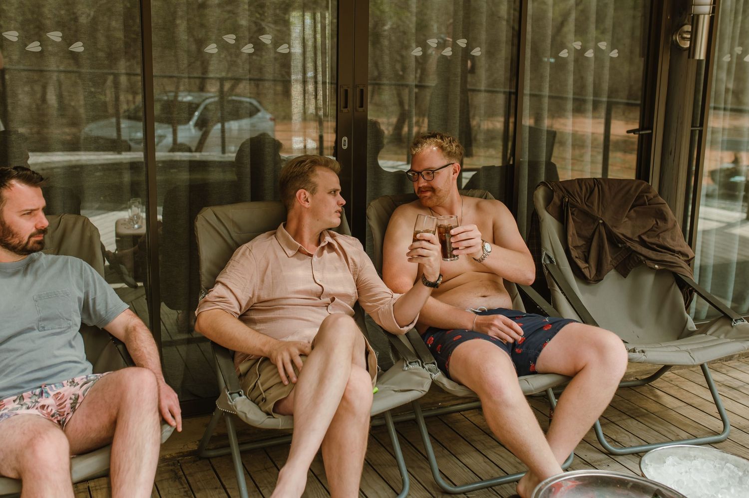 People relaxing on outdoor furniture under a covered patio.