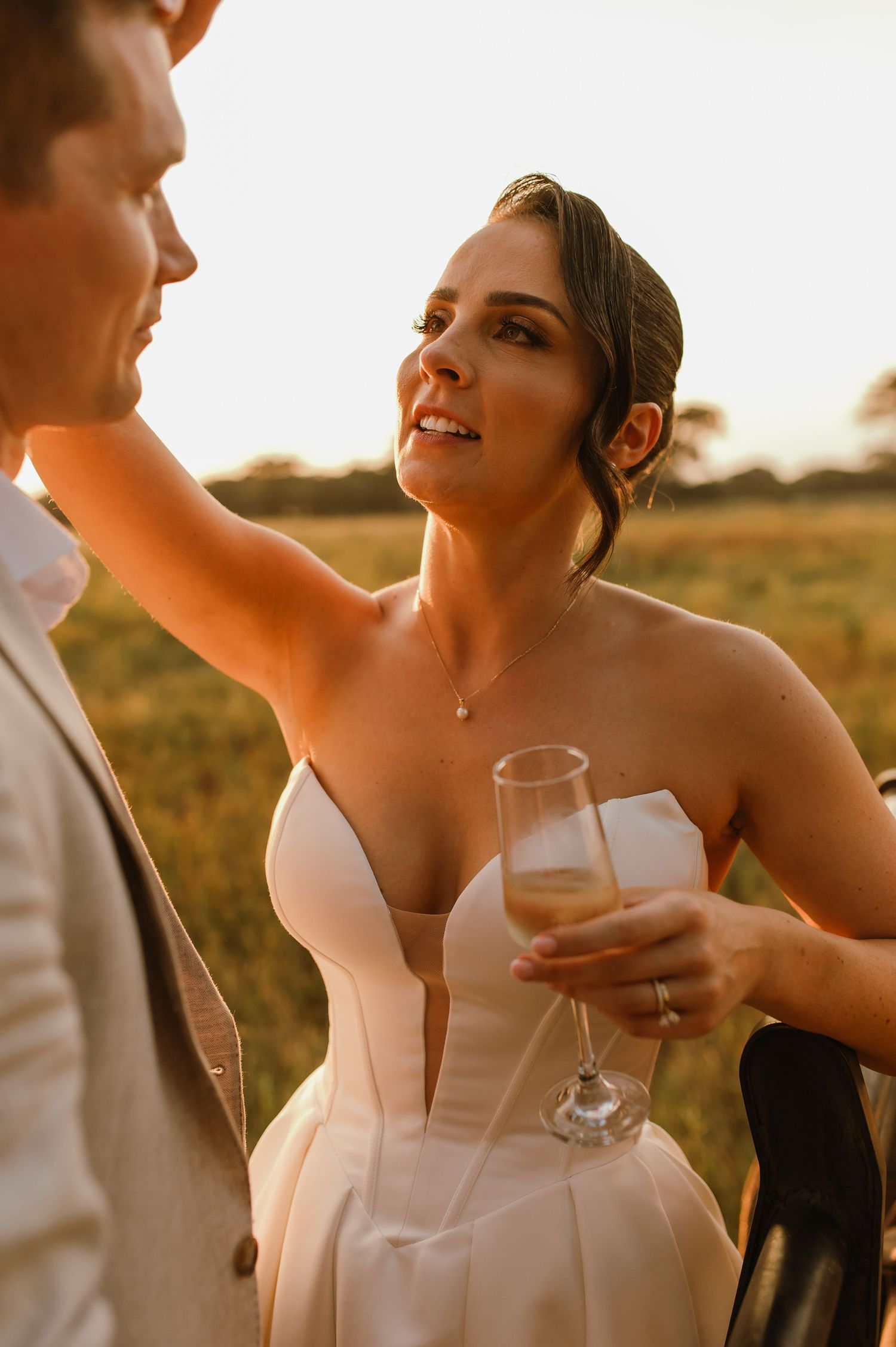Close-up wedding photos of couple sharing drinks and laughter during golden hour.