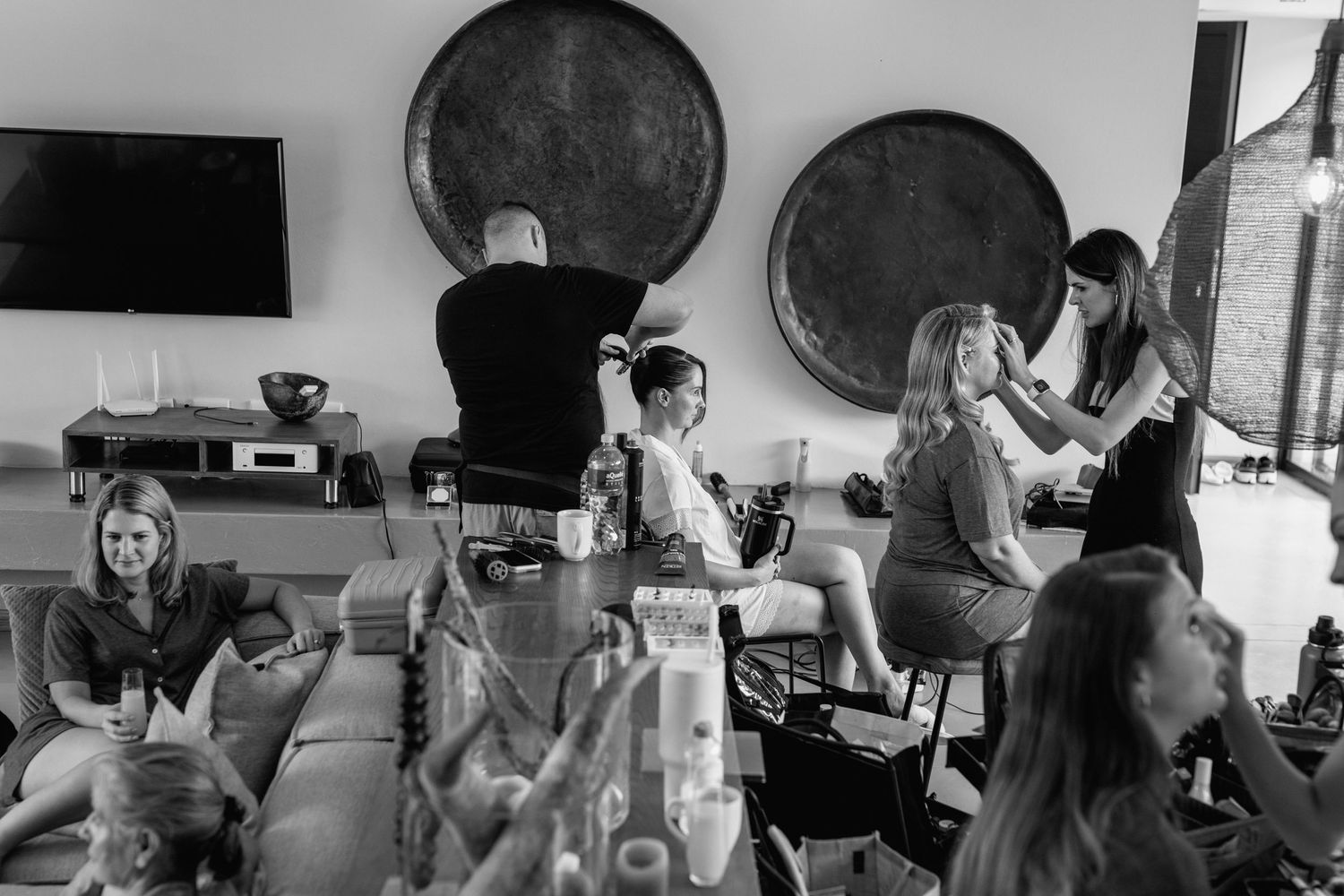 Black and white photo of a salon interior with wine glasses and decorative barrel displays.