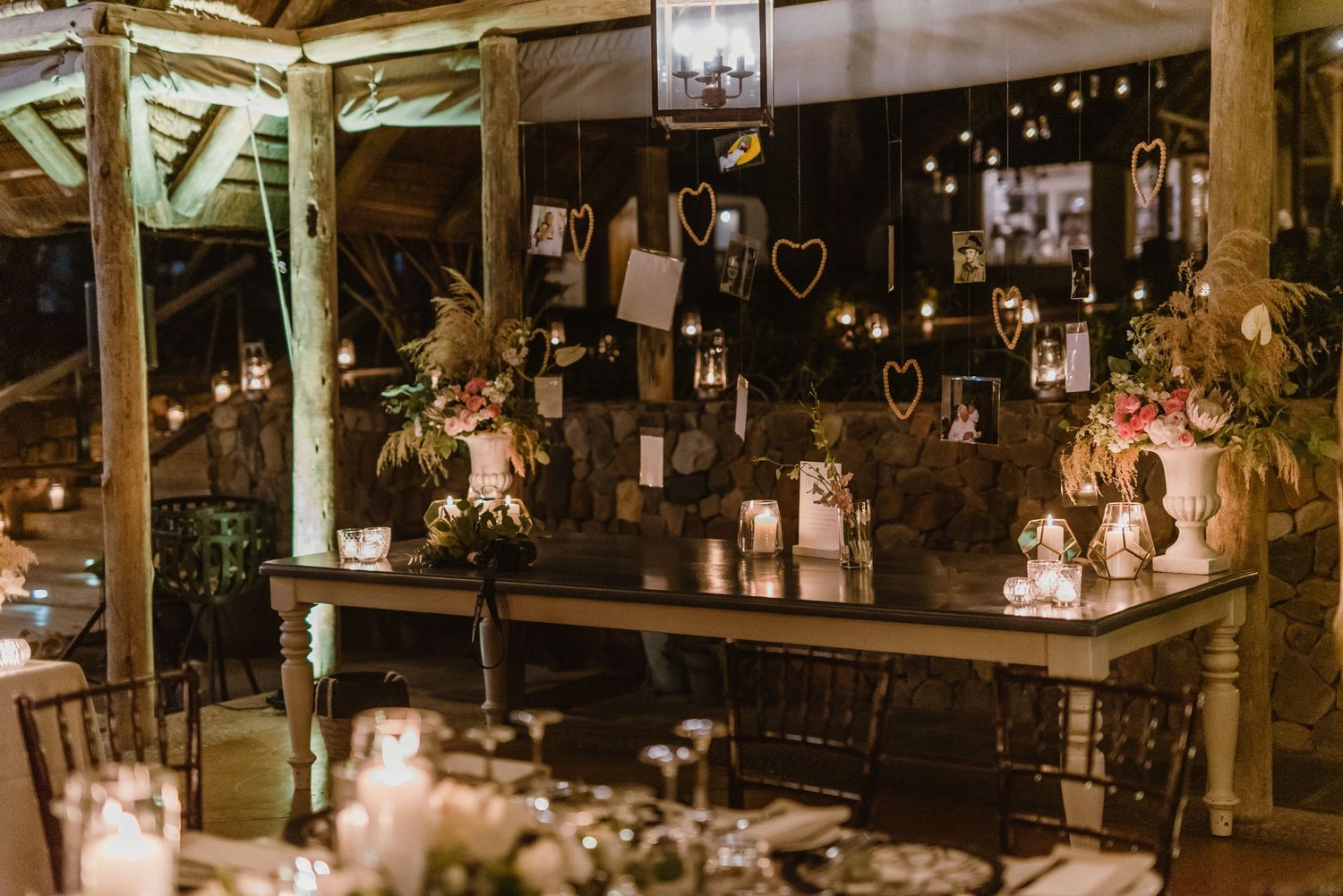 Rustic barn wedding reception venue decorated with romantic string lights and wooden beams.