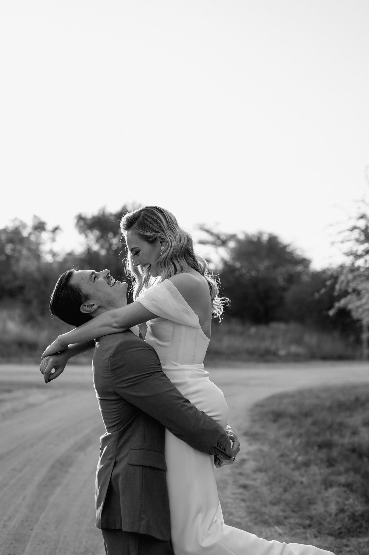 Black and white portrait of a couple sharing an intimate moment at sunset.