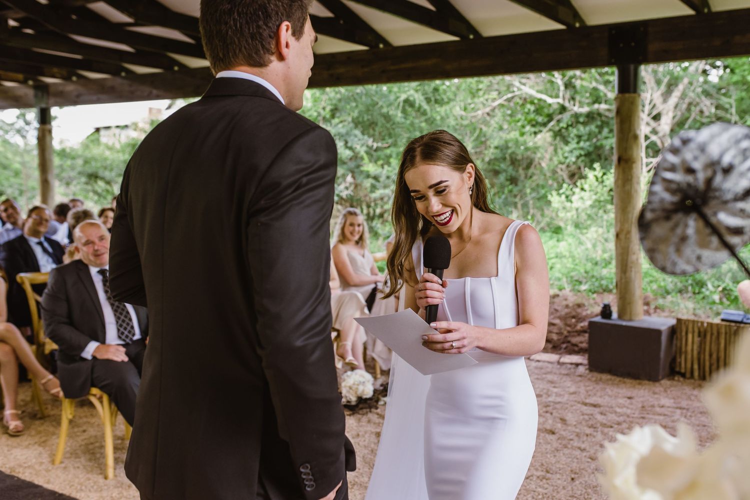 Couple shares their first dance under a rustic wooden pavilion.