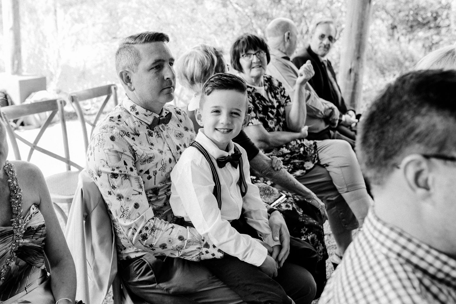 Wedding guests enjoying a celebration at a covered outdoor venue with natural lighting.