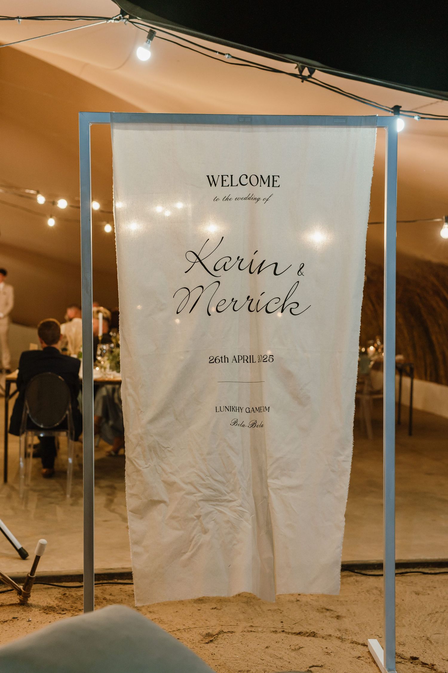 Welcome sign display with elegant script text at evening wedding reception.