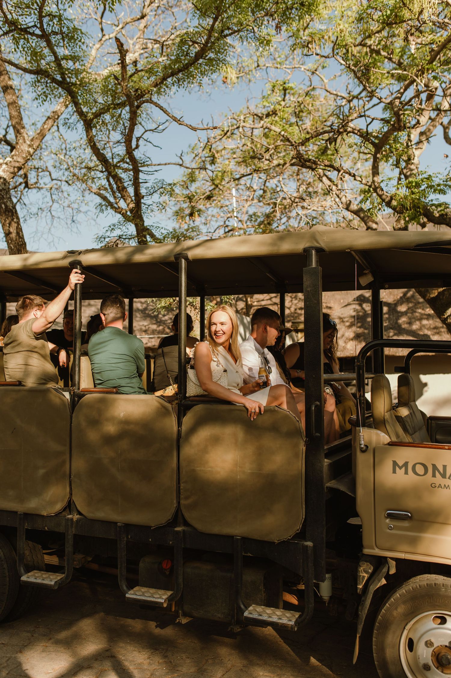 Side view of safari vehicles lined up with passengers boarding.