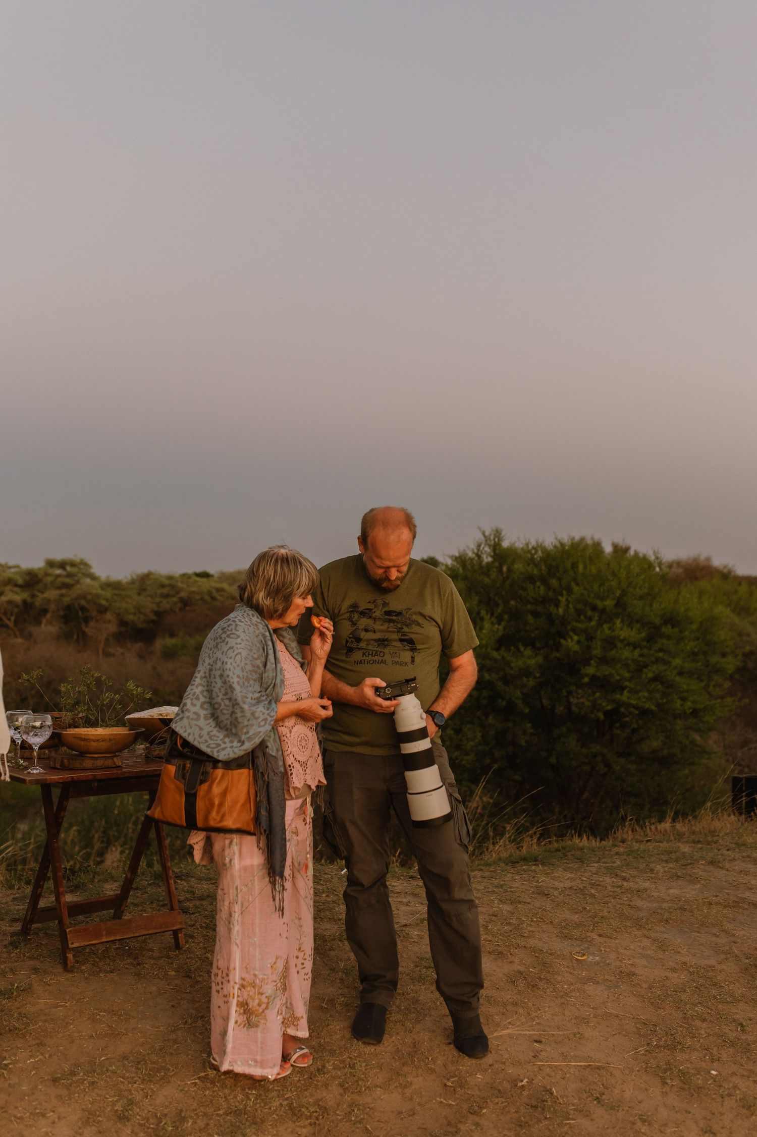 Couples dancing together at an outdoor party during sunset.