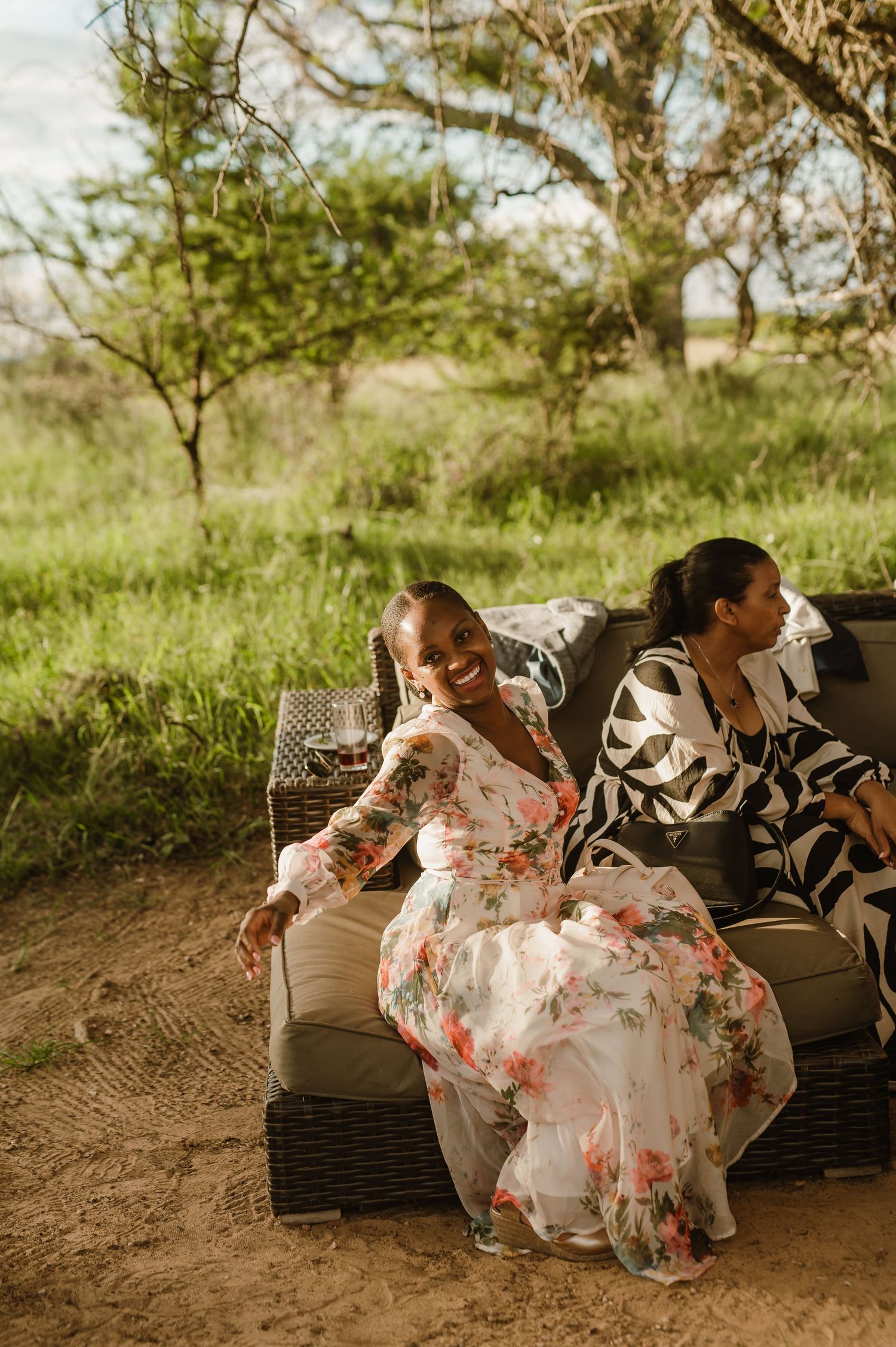Couple relaxing on outdoor wicker furniture during a sunset celebration.