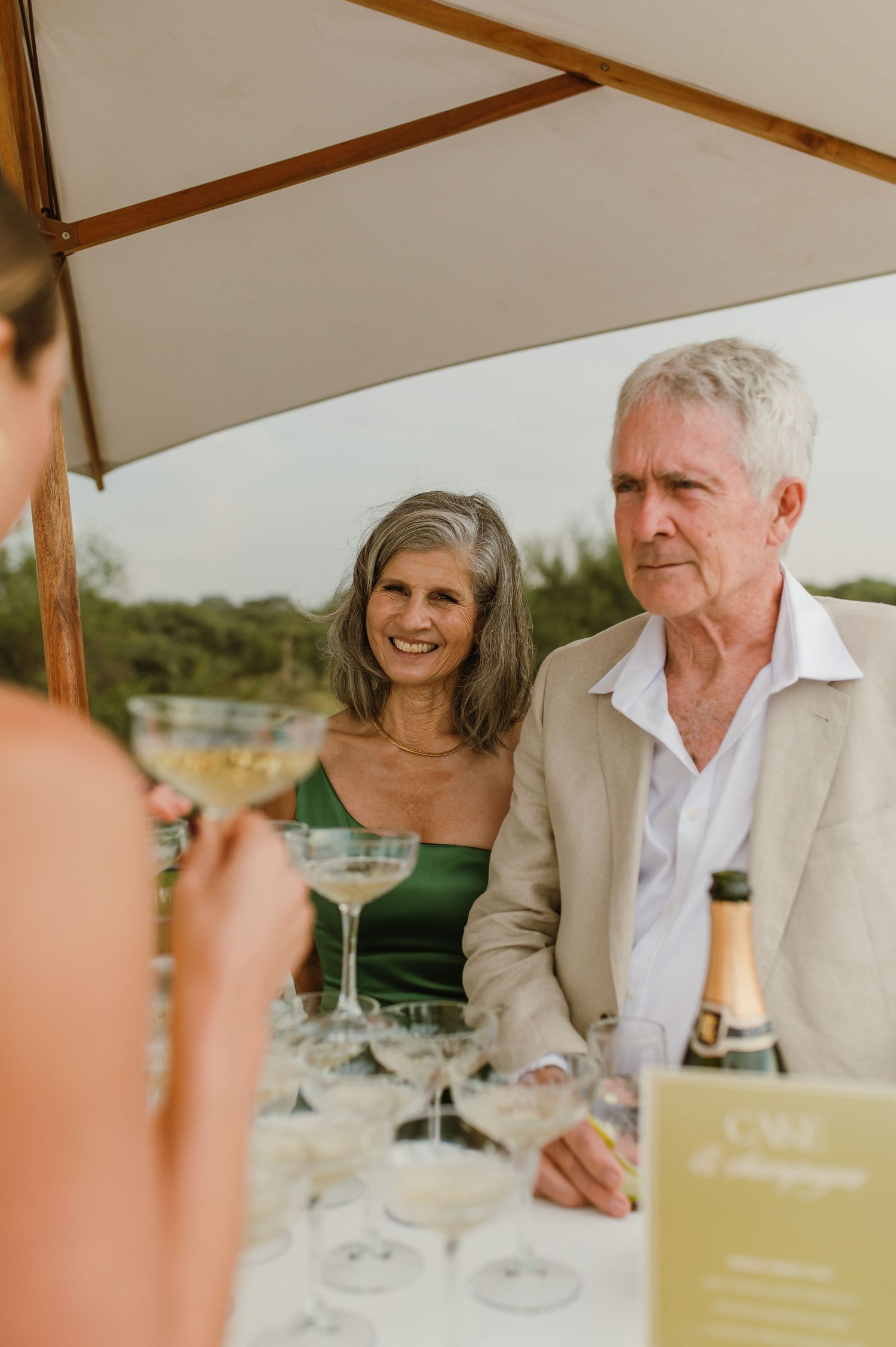 Elegant table setting with champagne and place cards for an outdoor celebration.