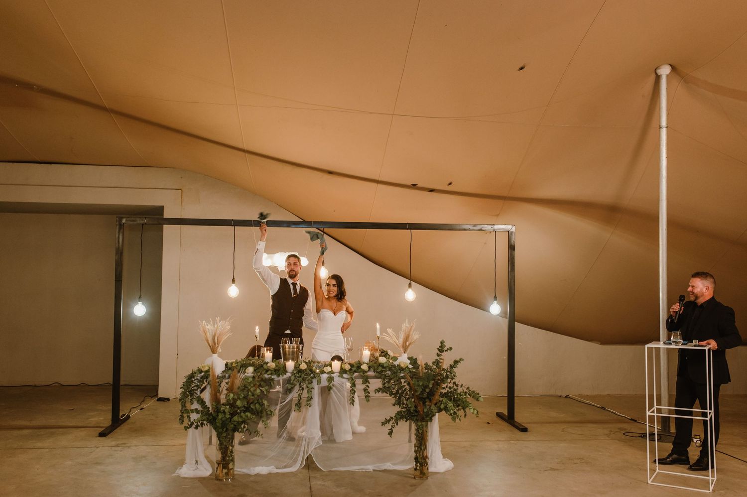 Wedding tent decorated with string lights and romantic lighting for an evening celebration.