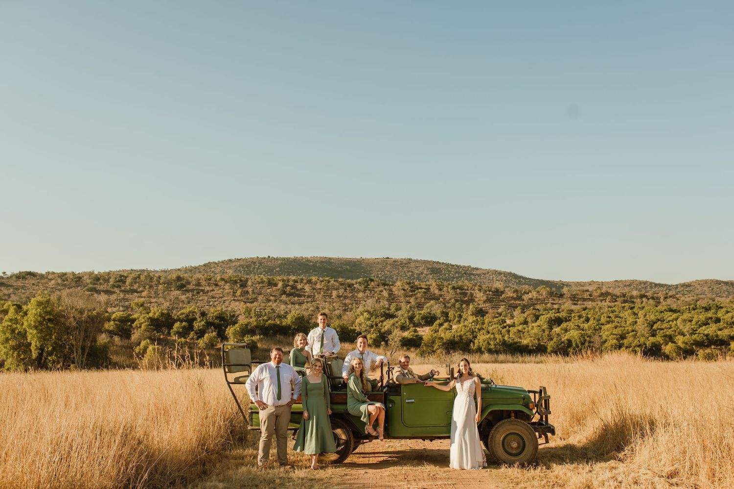 Desert landscape wedding venue with natural grass and mountain views at sunset.