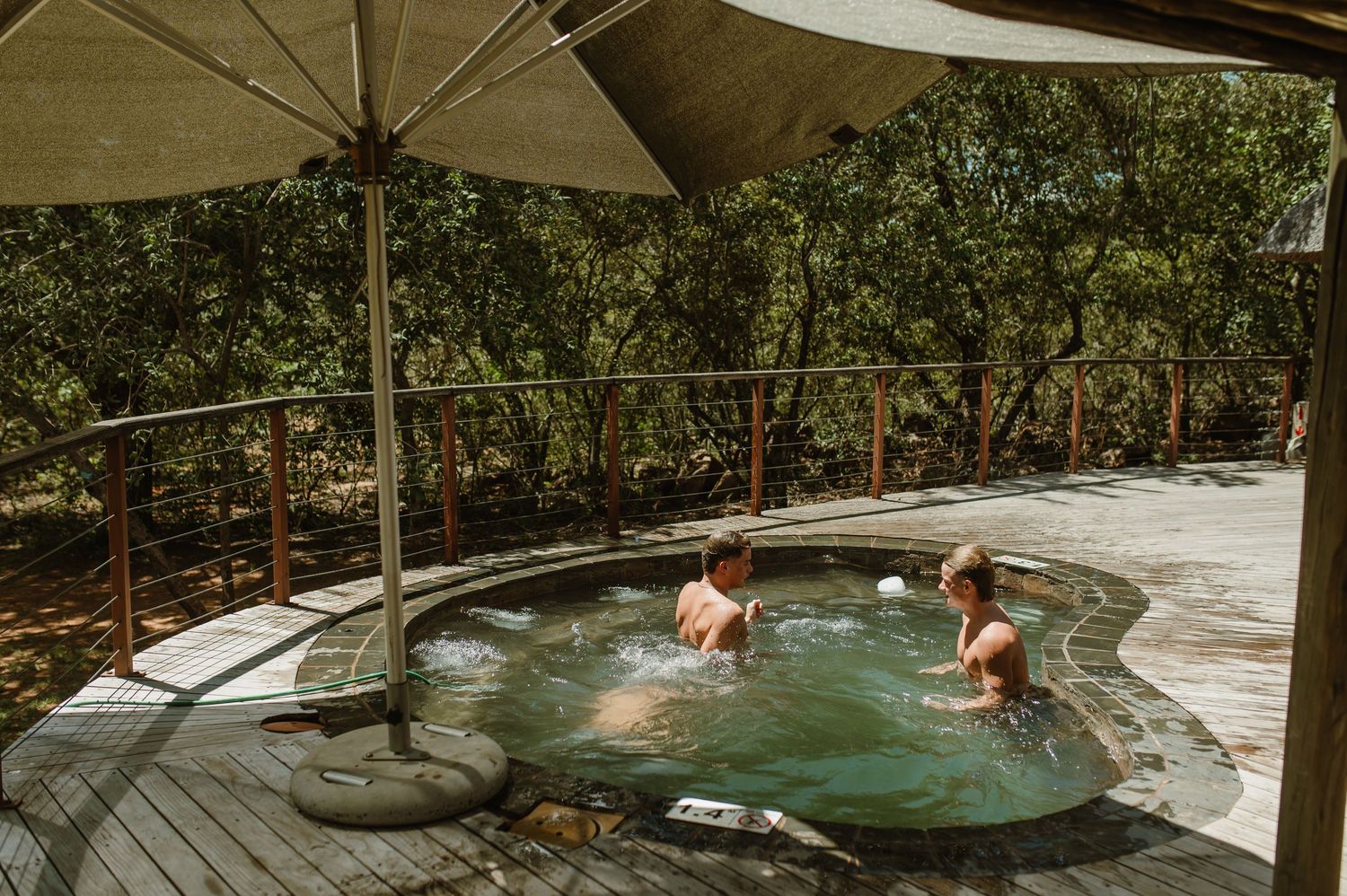 Group enjoying a refreshing swim in a natural pool surrounded by lush tropical vegetation.