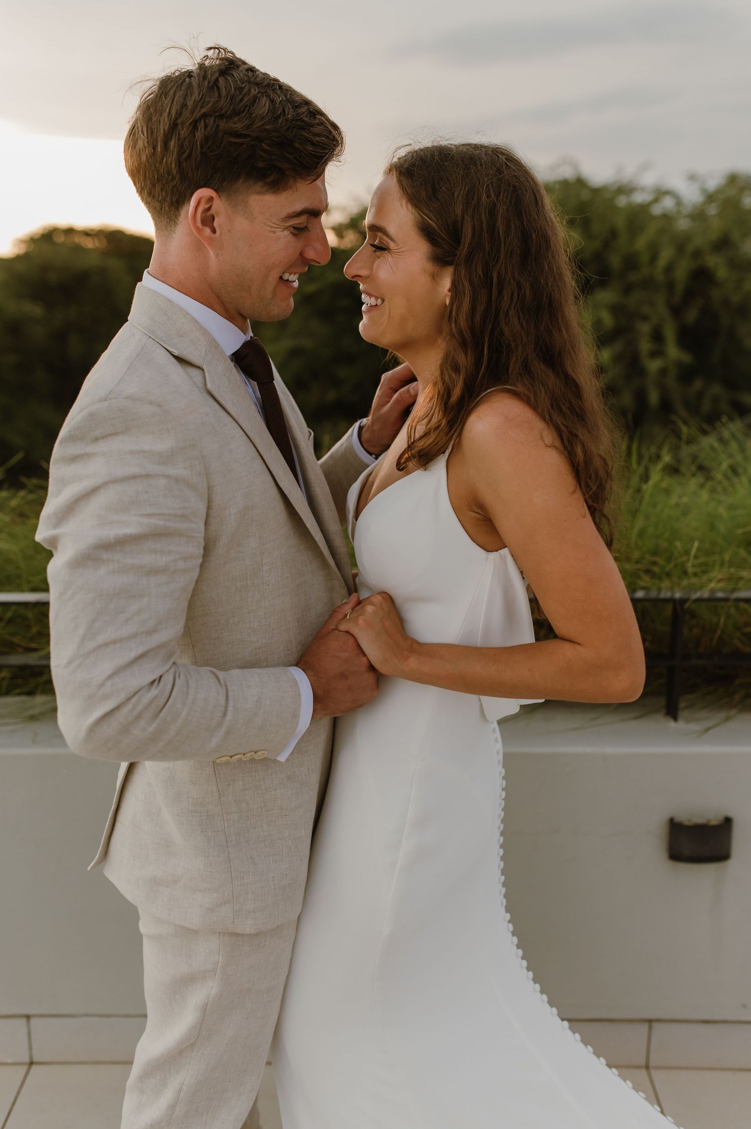 Intimate wedding moments shared between couple in light colored attire against neutral backdrop.