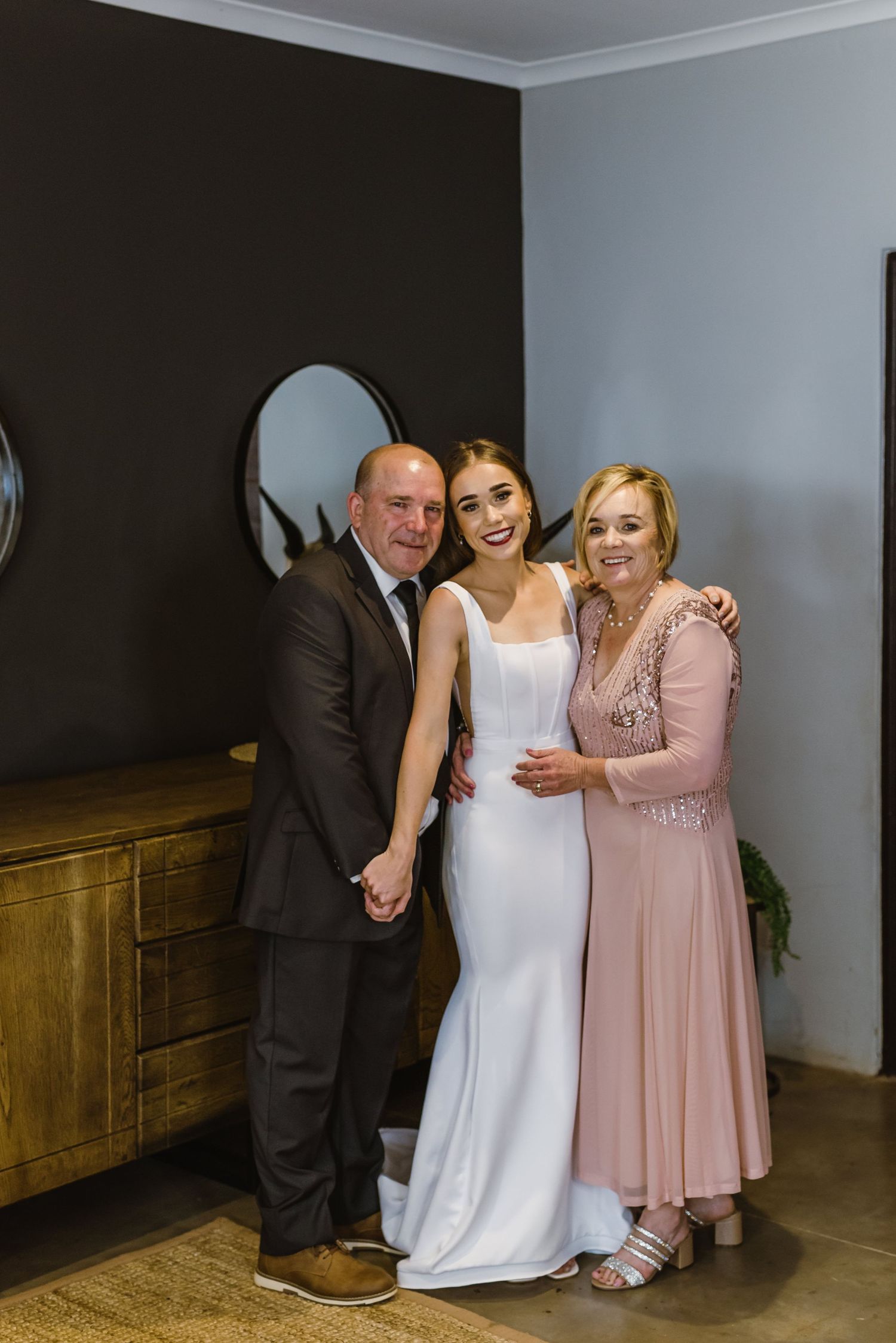 Wedding party sharing emotional moments in a rustic-styled room.