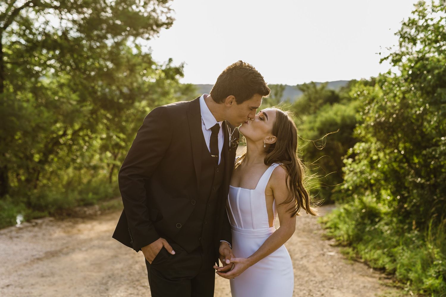 Romantic sunset moment between newlyweds on a rustic path.