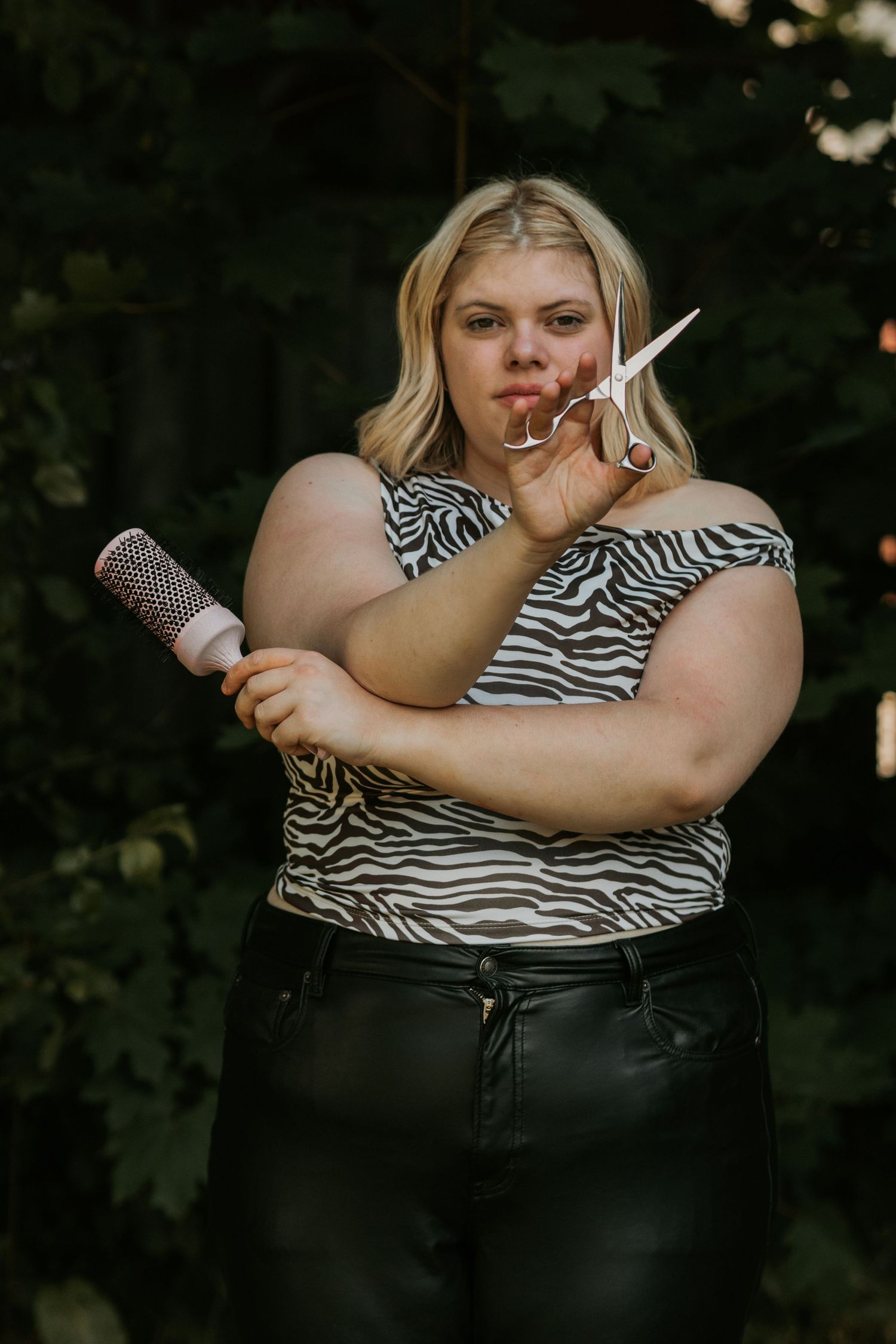 Styling demonstration with brushes and combs against dark background.