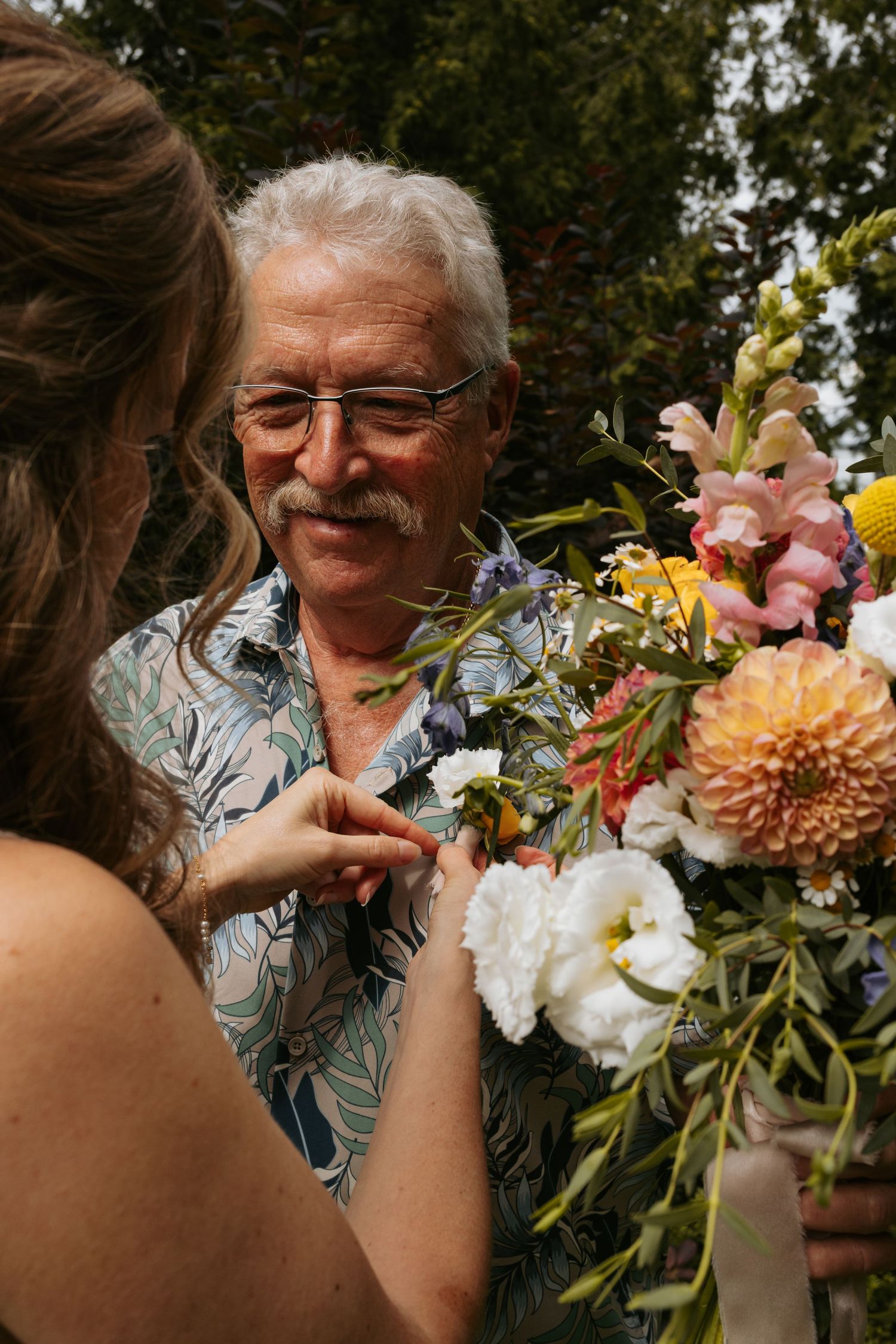 Joyful moment with colorful floral bouquet being presented outdoors.