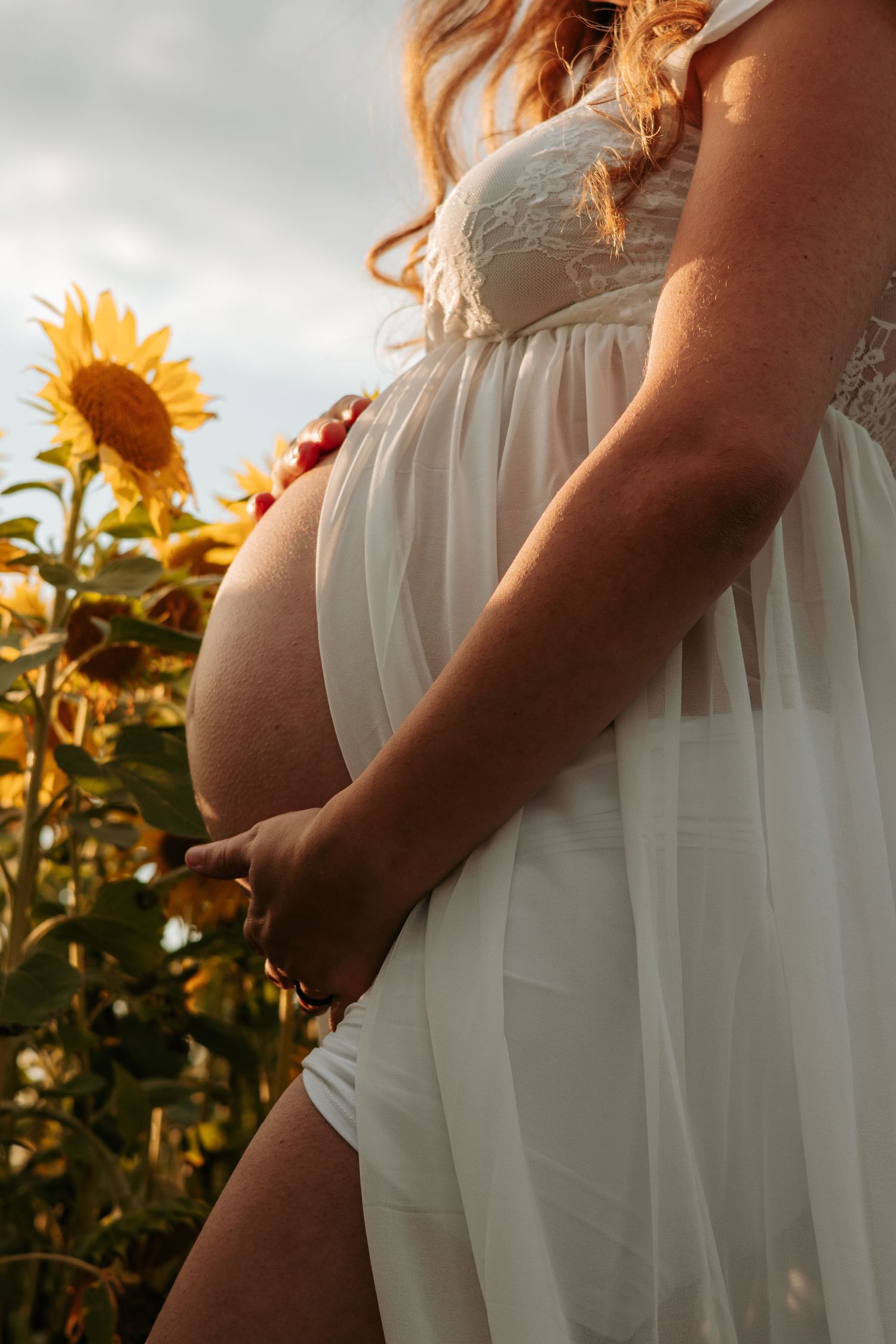 Series of pregnancy photos showing growing baby bump in flowing white dress.