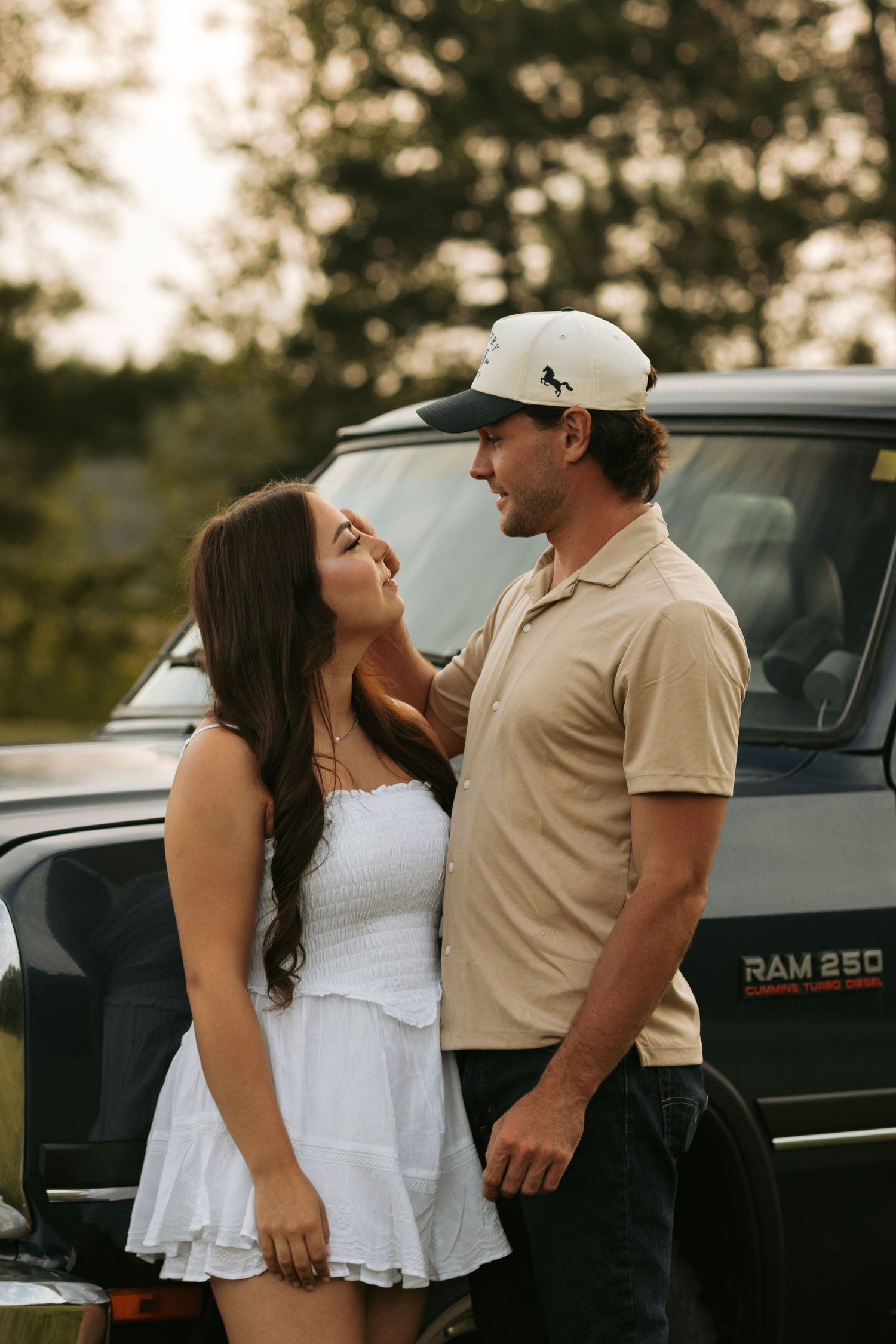 Couple sharing romantic moment by vintage truck at sunset.